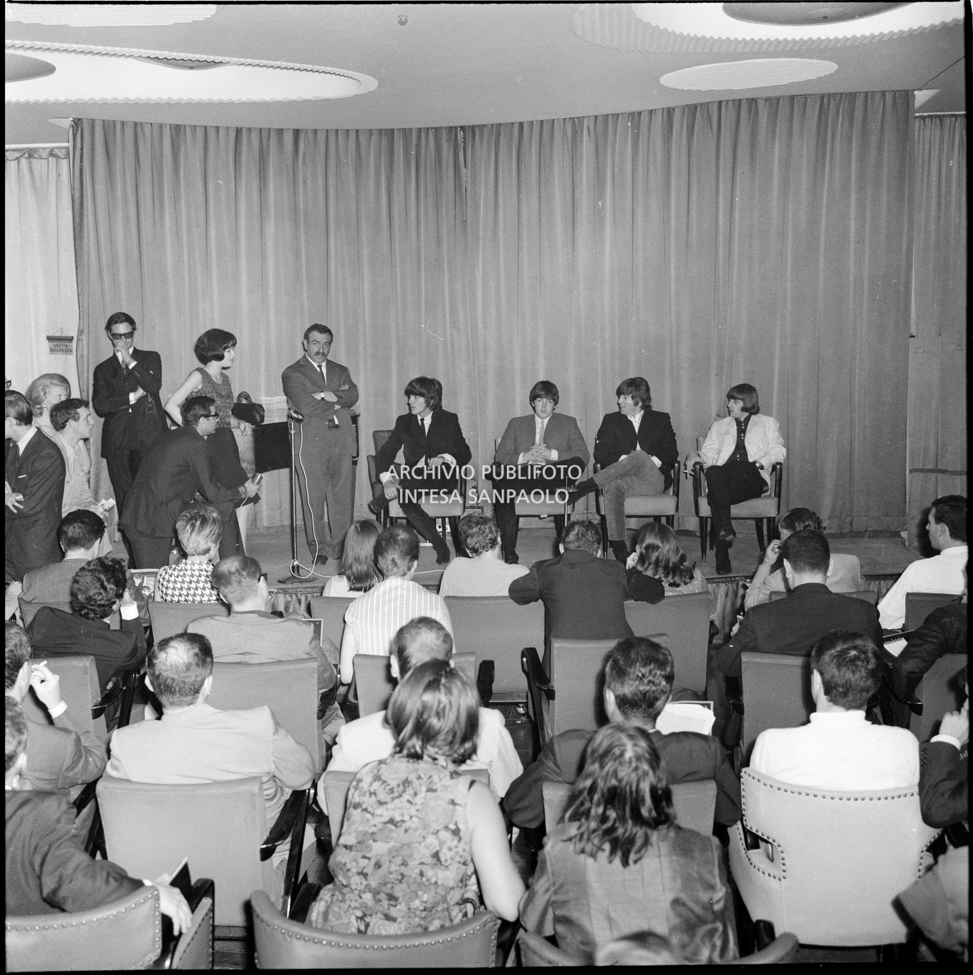 I Beatles in conferenza stampa al Grand Hotel Duomo a Milano; da sinistra il manager Brian Epstein e Leo Wächter, l'impresario che portò la band inglese in Italia