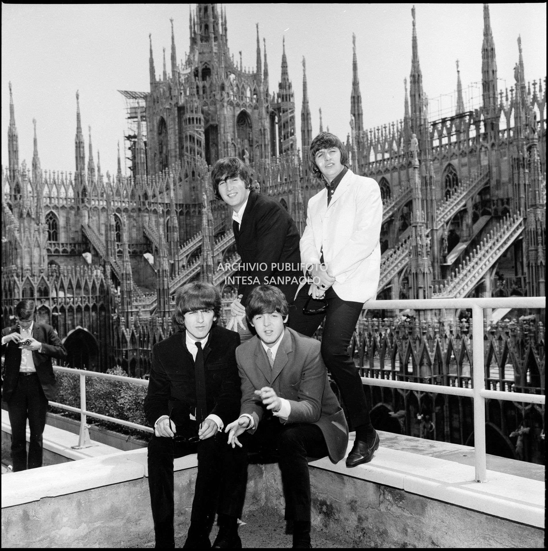 I Beatles ritratti sulla terrazza del Grand Hotel Duomo a Milano; sullo sfondo le guglie della cattedrale