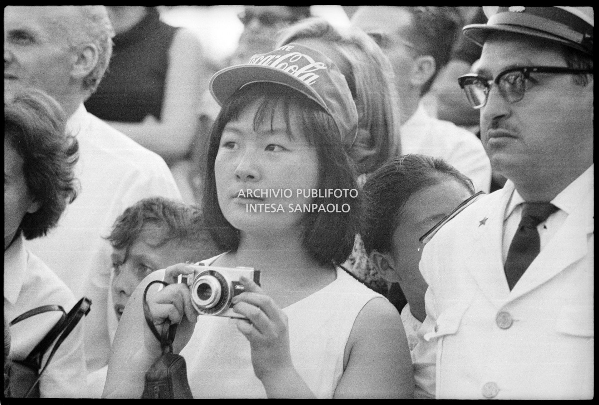 Una spettatrice con macchina fotografica tra il pubblico al concerto pomeridiano dei Beatles al Vigorelli di Milano
