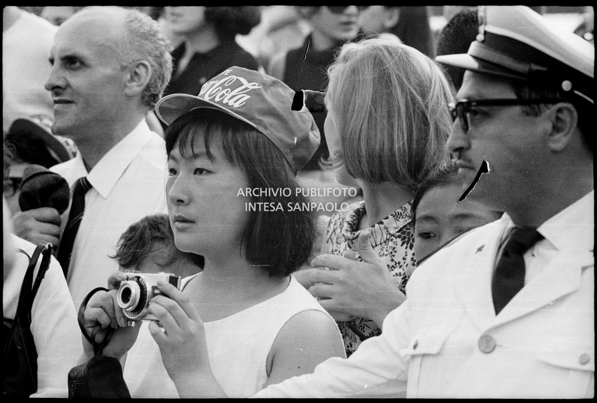 Una spettatrice con macchina fotografica tra il pubblico al concerto pomeridiano dei Beatles al Vigorelli di Milano