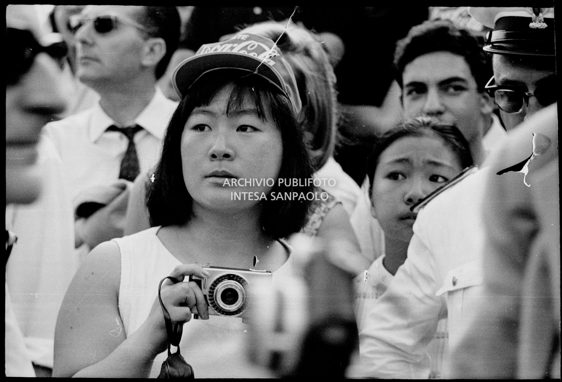 Una spettatrice con macchina fotografica tra il pubblico al concerto pomeridiano dei Beatles al Vigorelli di Milano