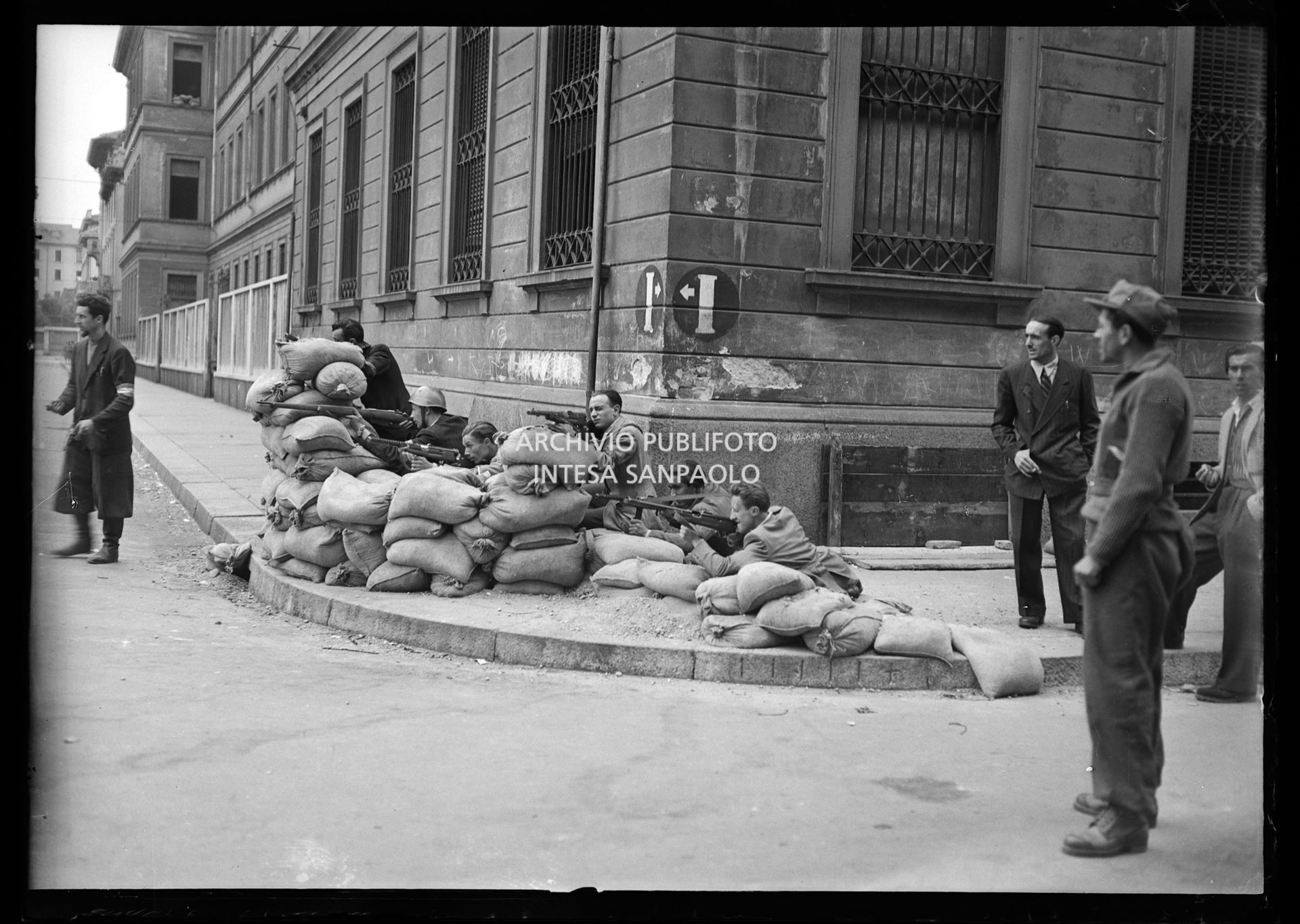 Insurrezione generale del C.V.L. (Corpo Volontari della Libertà) in piazza Lavater a Milano, con passanti che osservano la scena