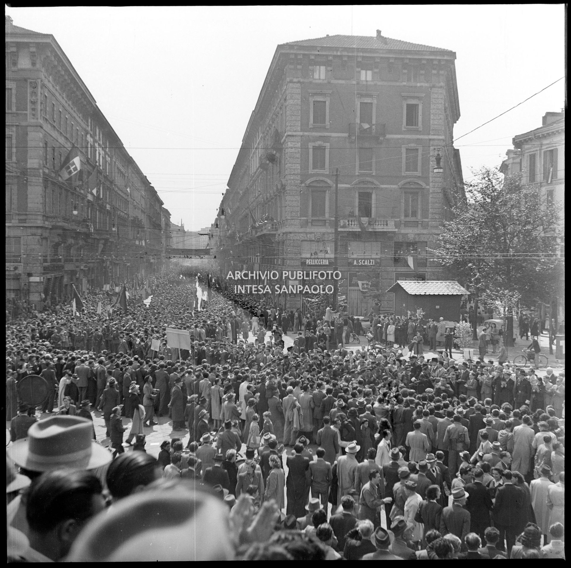 Folla in via Dante a Milano assiste alla sfilata delle formazioni partigiane