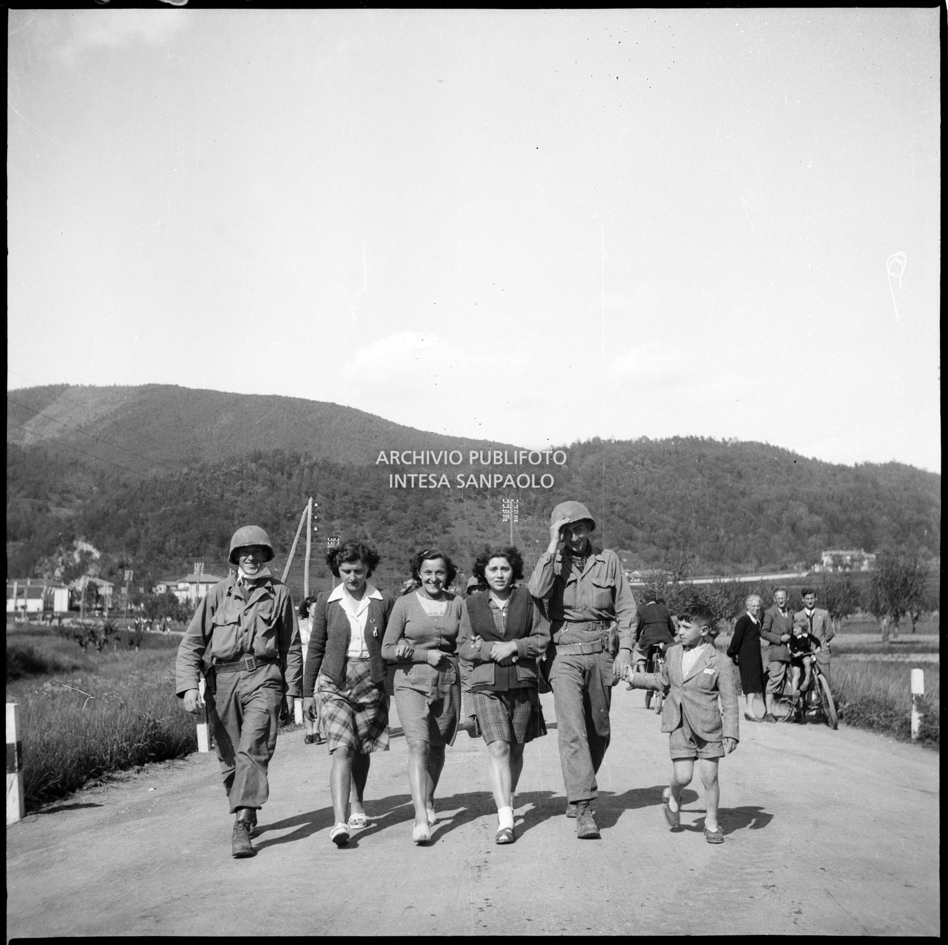 Militari americani in marcia verso Milano nella quinta giornata di insurrezione generale ritratti con tre ragazze e un bambino