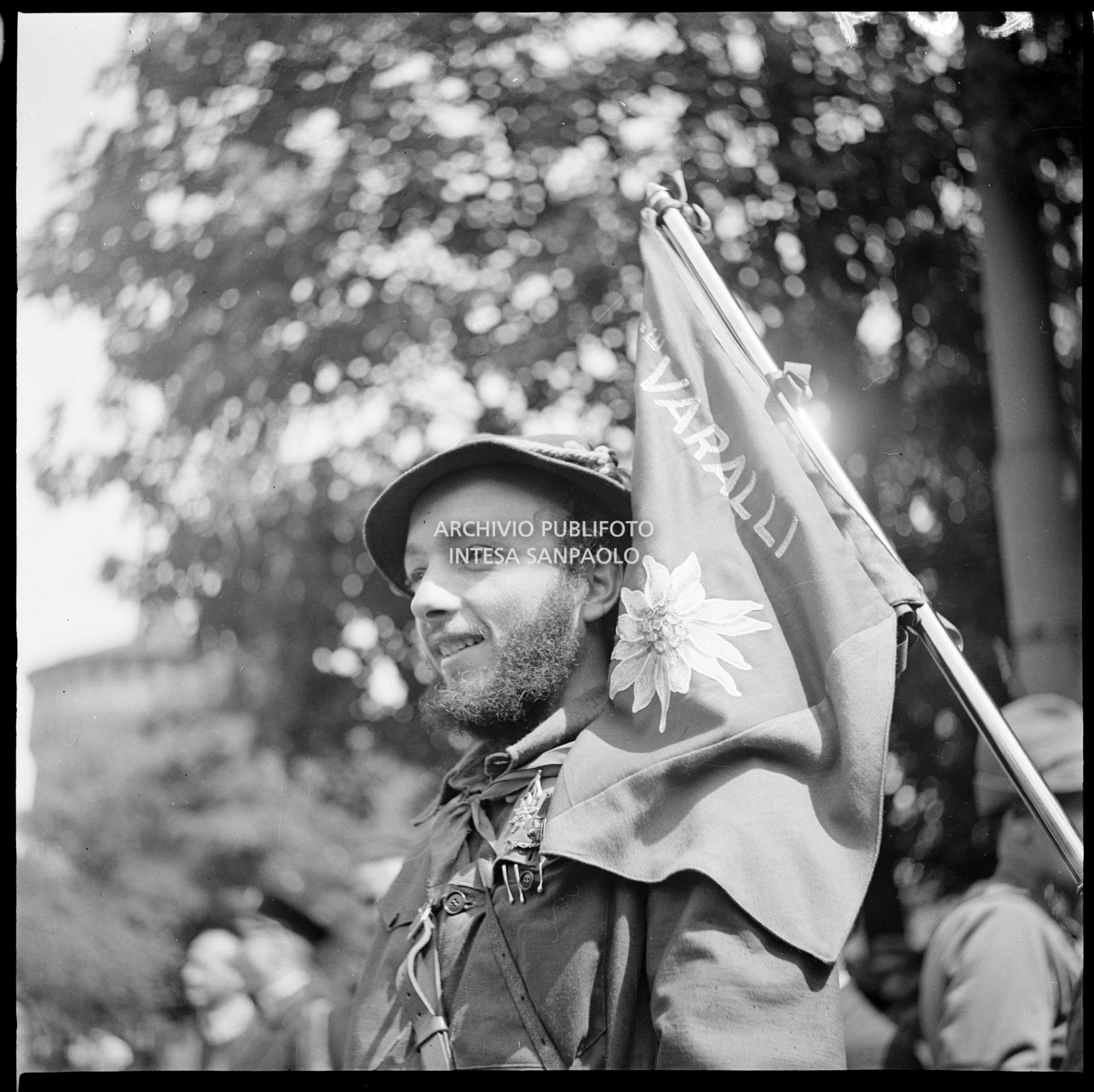 Ritratto di un membro del C.V.L. (Corpo Volontari della Libertà) durante la manifestazione in piazza Castello in onore delle formazioni partigiane; sulla spalla la bandiera della 1a Divisione Fratelli Varalli