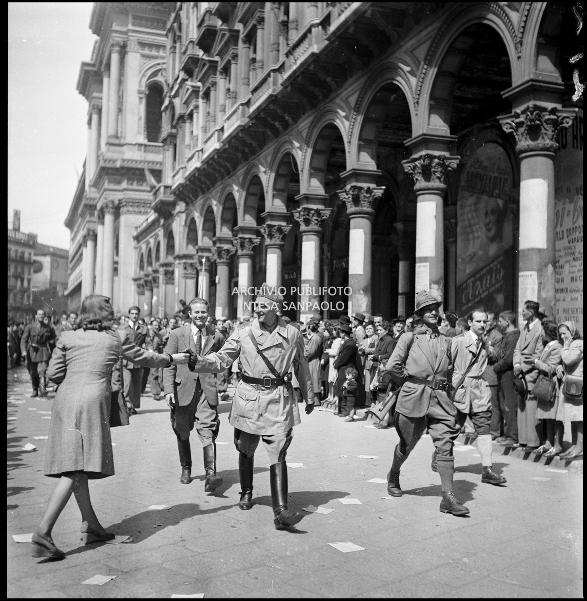 Una ragazza saluta il generale Ratti del C.V.L. (Corpo Volontari della Libertà) che sfila in piazza del Duomo a Milano insieme alle formazioni partigiane