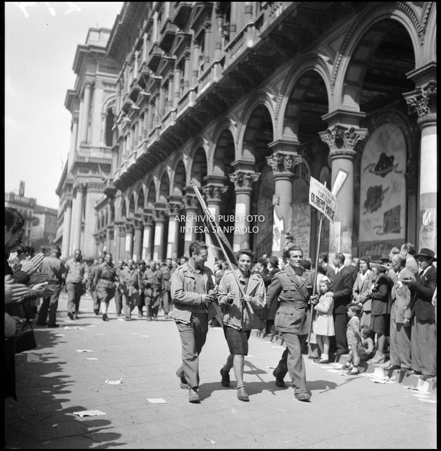 Sfilata in piazza del Duomo a Milano delle formazioni partigiane; sul cartello "Partigiani dell'Oltrepo Pavese"