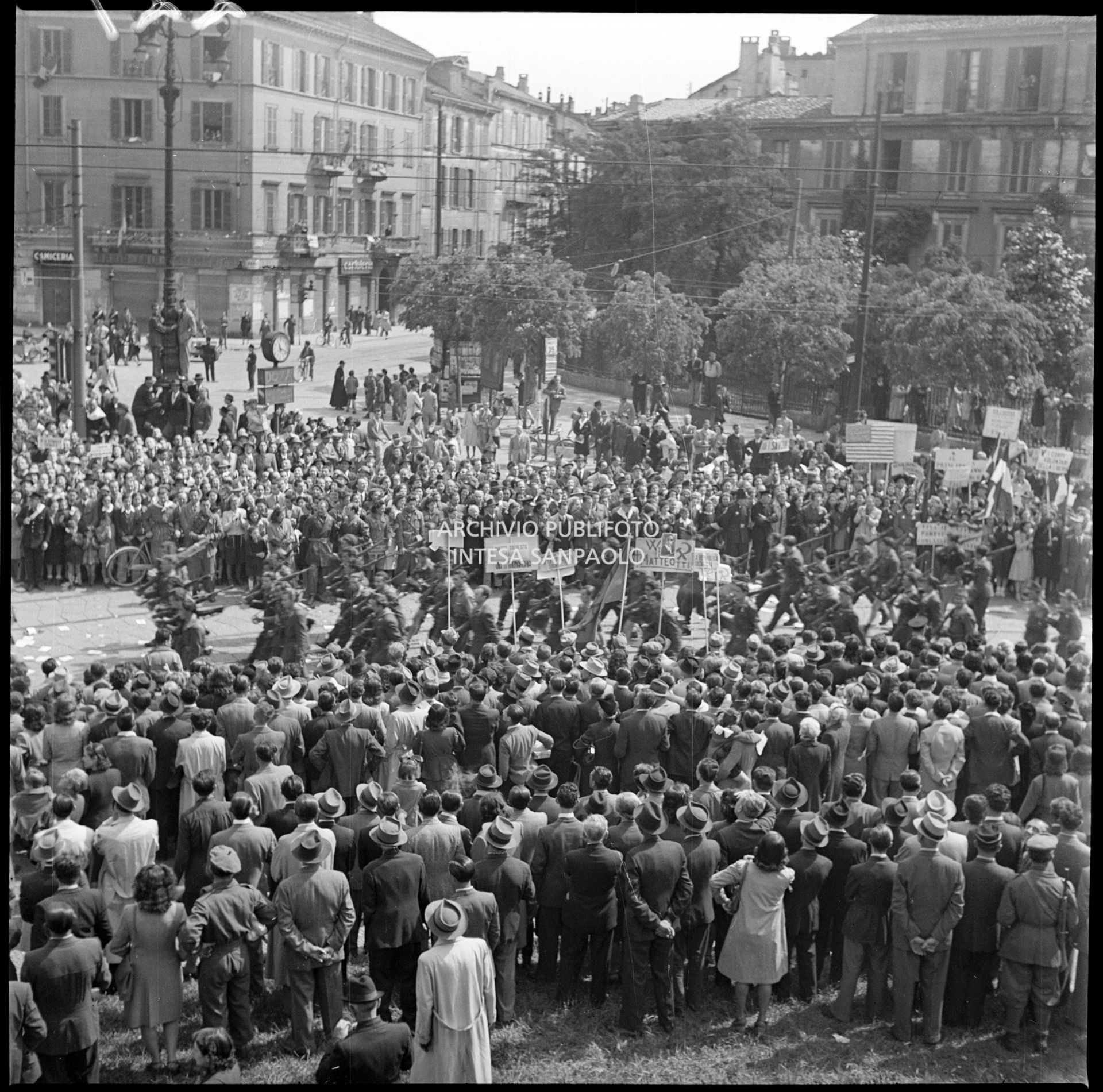 Folla in largo Cairoli a Milano assiste alla sfilata delle formazioni partigiane