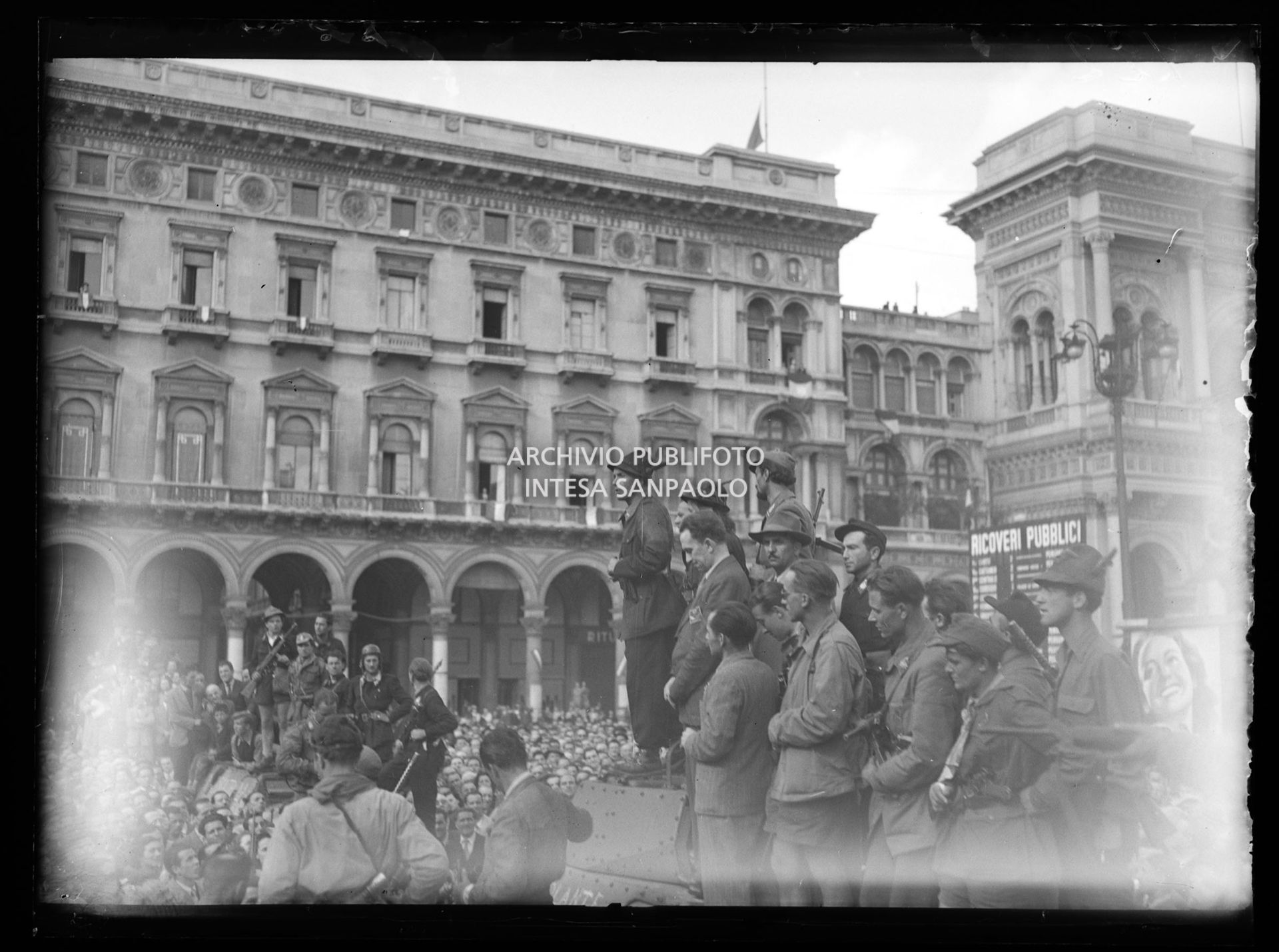 Le colonne partigiane arrivano in piazza del Duomo a Milano e dal podio improvvisato sul tetto di un blindato Cino Moscatelli parla alla folla nella quarta giornata di insurrezione generale
