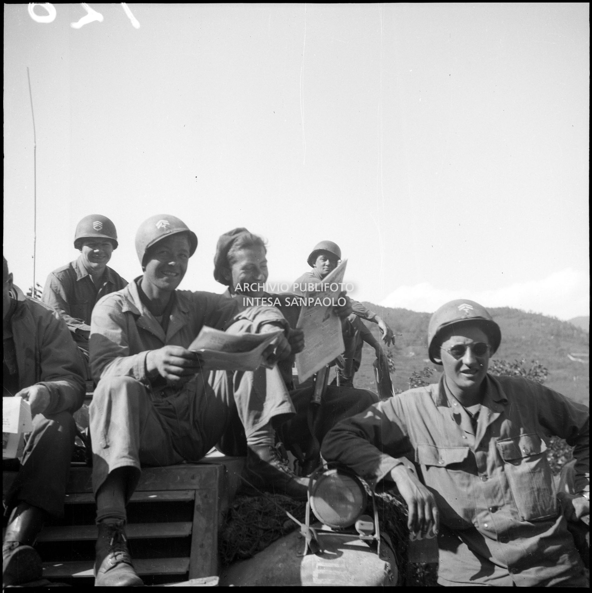 Militari americani leggono il giornale "Star and Stripes" durante una sosta nella marcia verso Milano nella quinta giornata dell'insurrezione generale