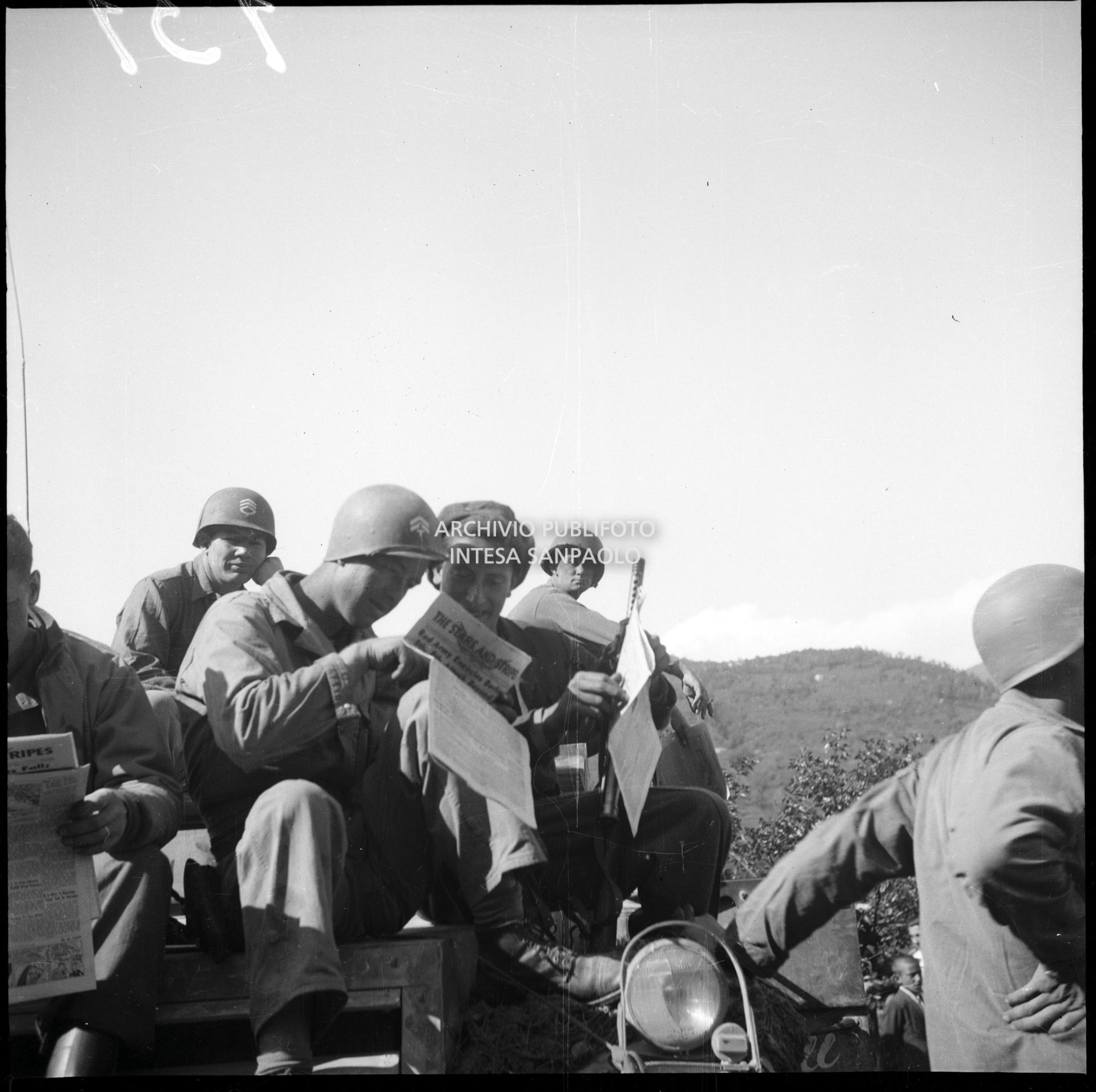 Militari americani leggono il giornale "Star and Stripes" durante una sosta nella marcia verso Milano nella quinta giornata dell'insurrezione generale