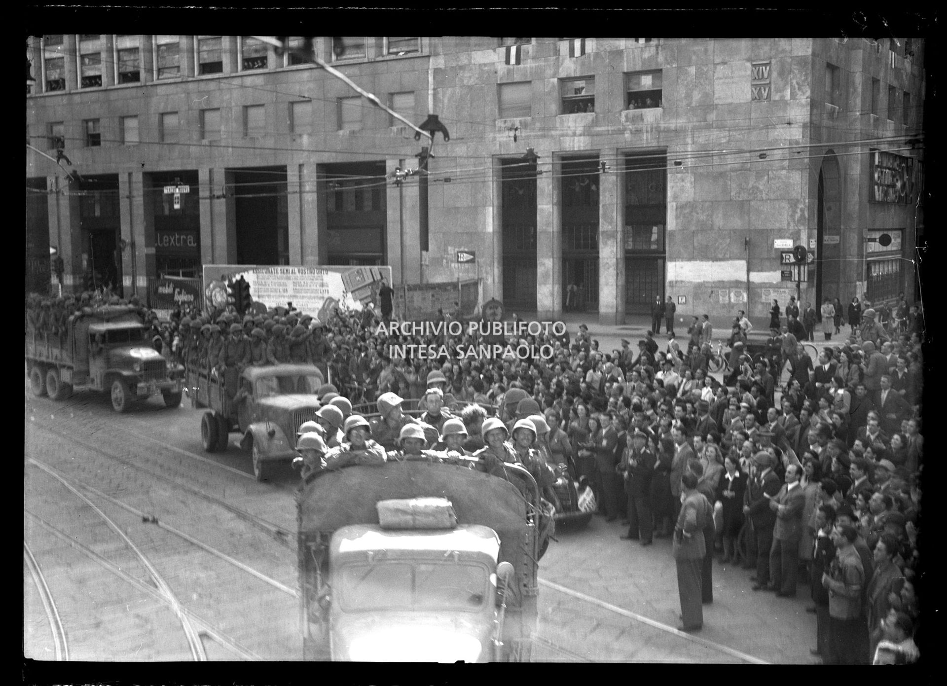 Colonna di mezzi delle truppe americane alleate sfilain piazza San Babila a Milano accolta dalla folla nella settima giornata di insurrezione generale