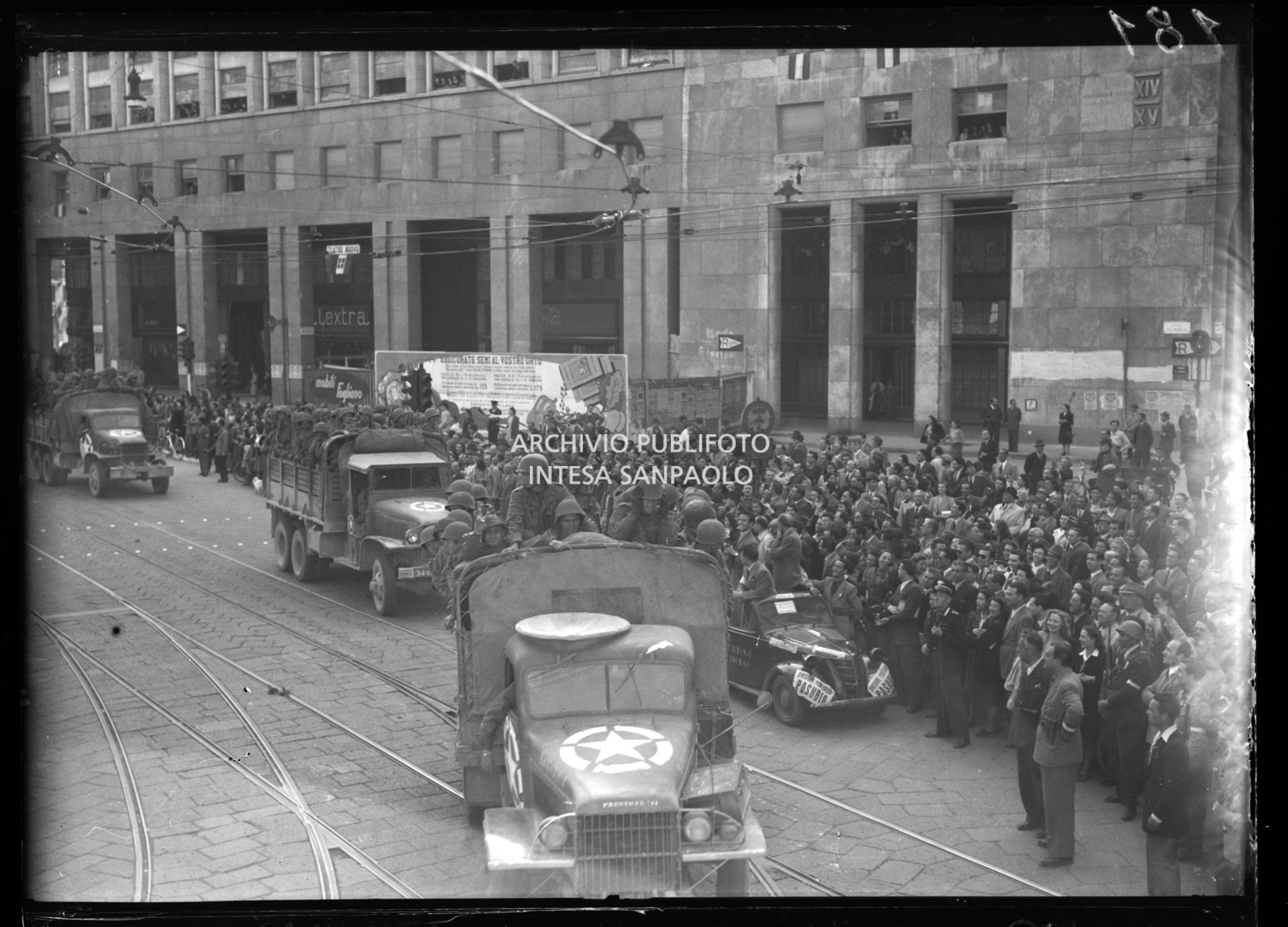 Colonna di mezzi delle truppe americane alleate sfilain piazza San Babila a Milano accolta dalla folla nella settima giornata di insurrezione generale