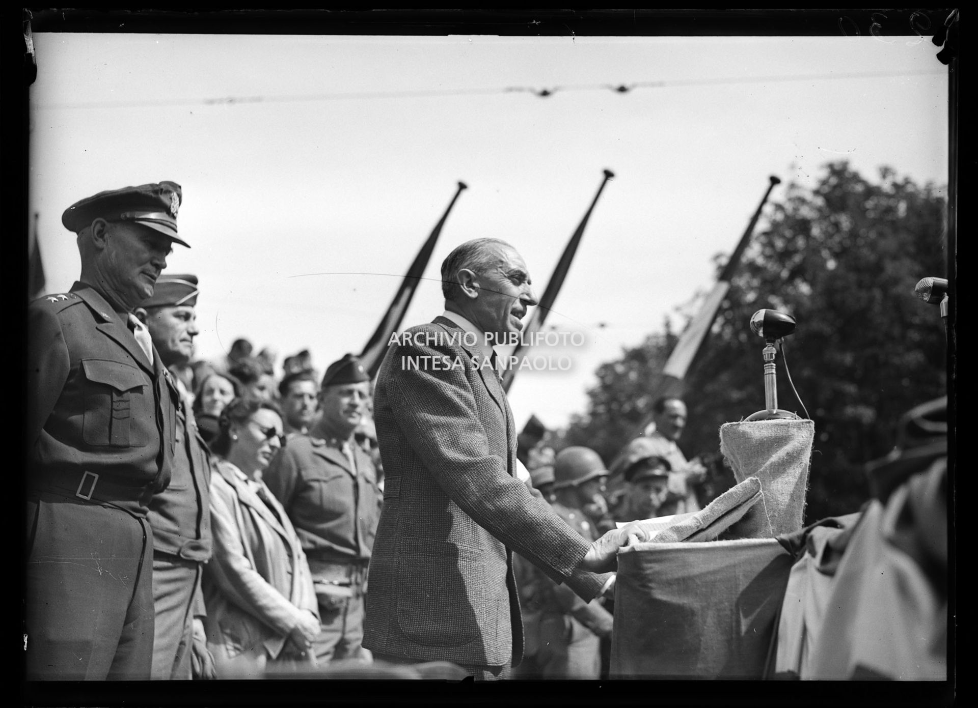 Intervento del generale Raffaele Cadorna alla manifestazione in onore delle formazioni partigiane in piazza Castello a Milano; alle sue spalle il generale americano Willis D. Crittenberger