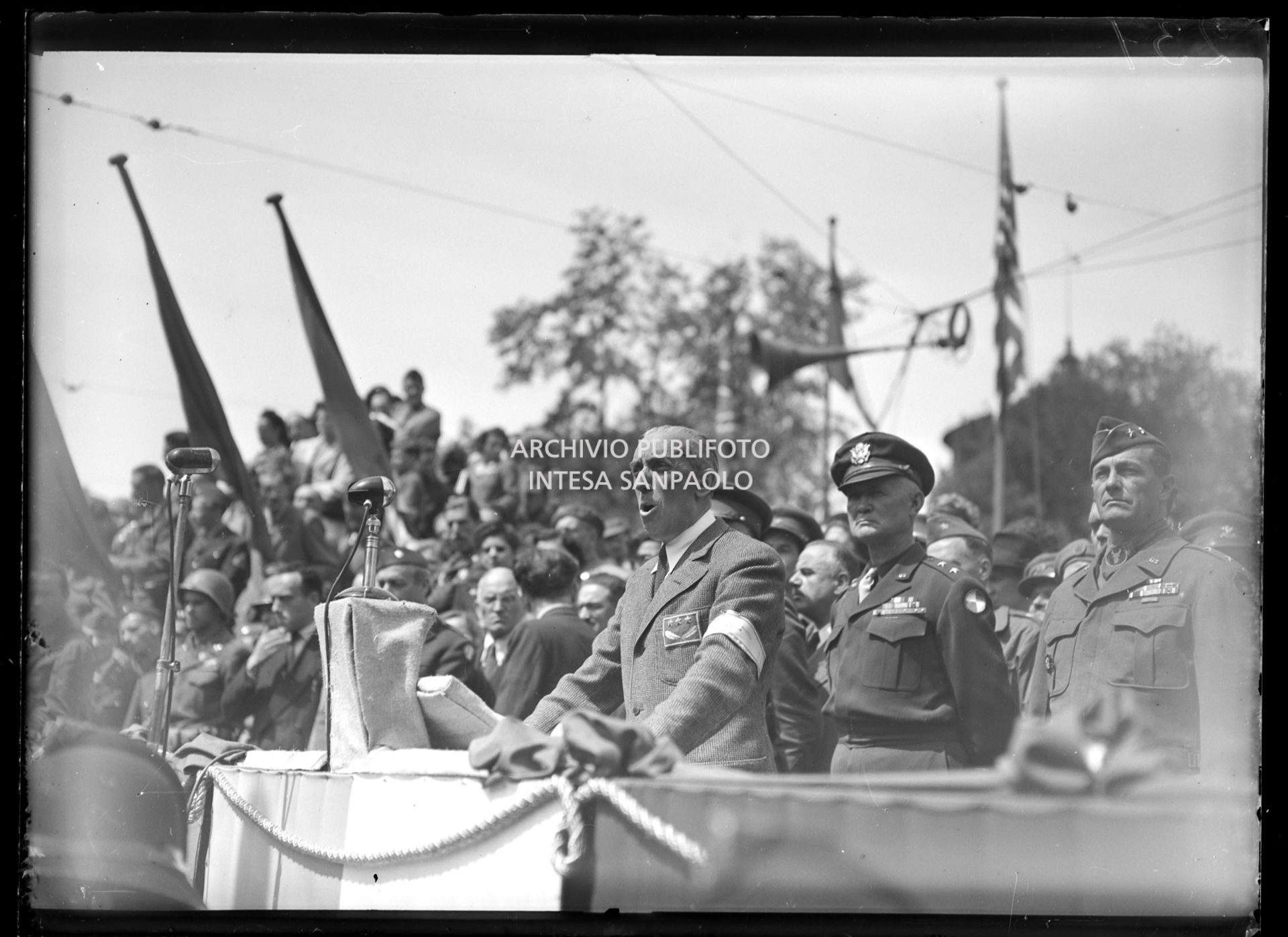 Intervento del generale Raffaele Cadorna alla manifestazione in onore delle formazioni partigiane in piazza Castello a Milano; alle sue spalle il generale americano Willis D. Crittenberger