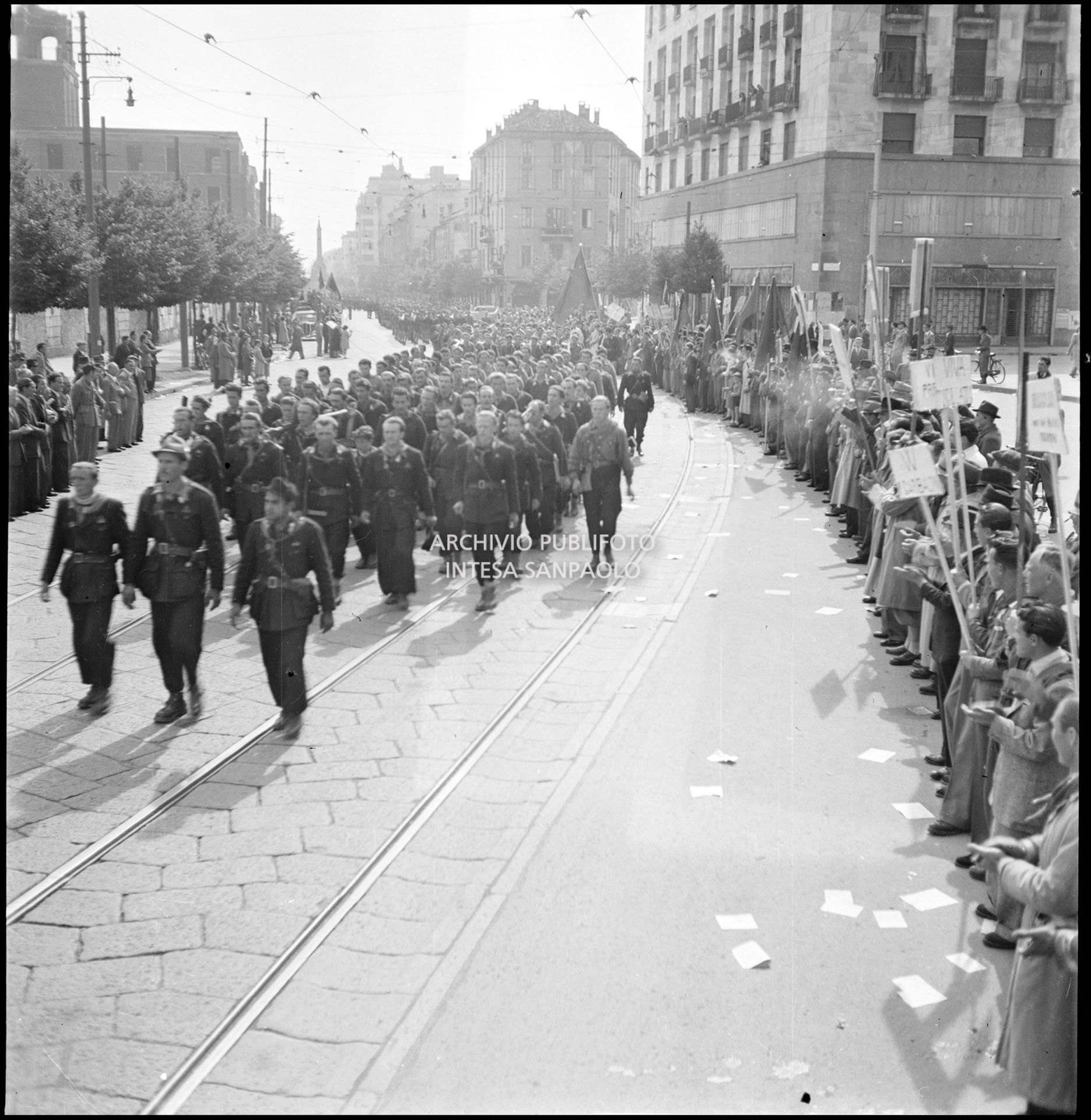 Le formazioni partigiane sfilano in corso di Porta Vittoria a Milano; ai lati la folla accorsa per festeggiarle