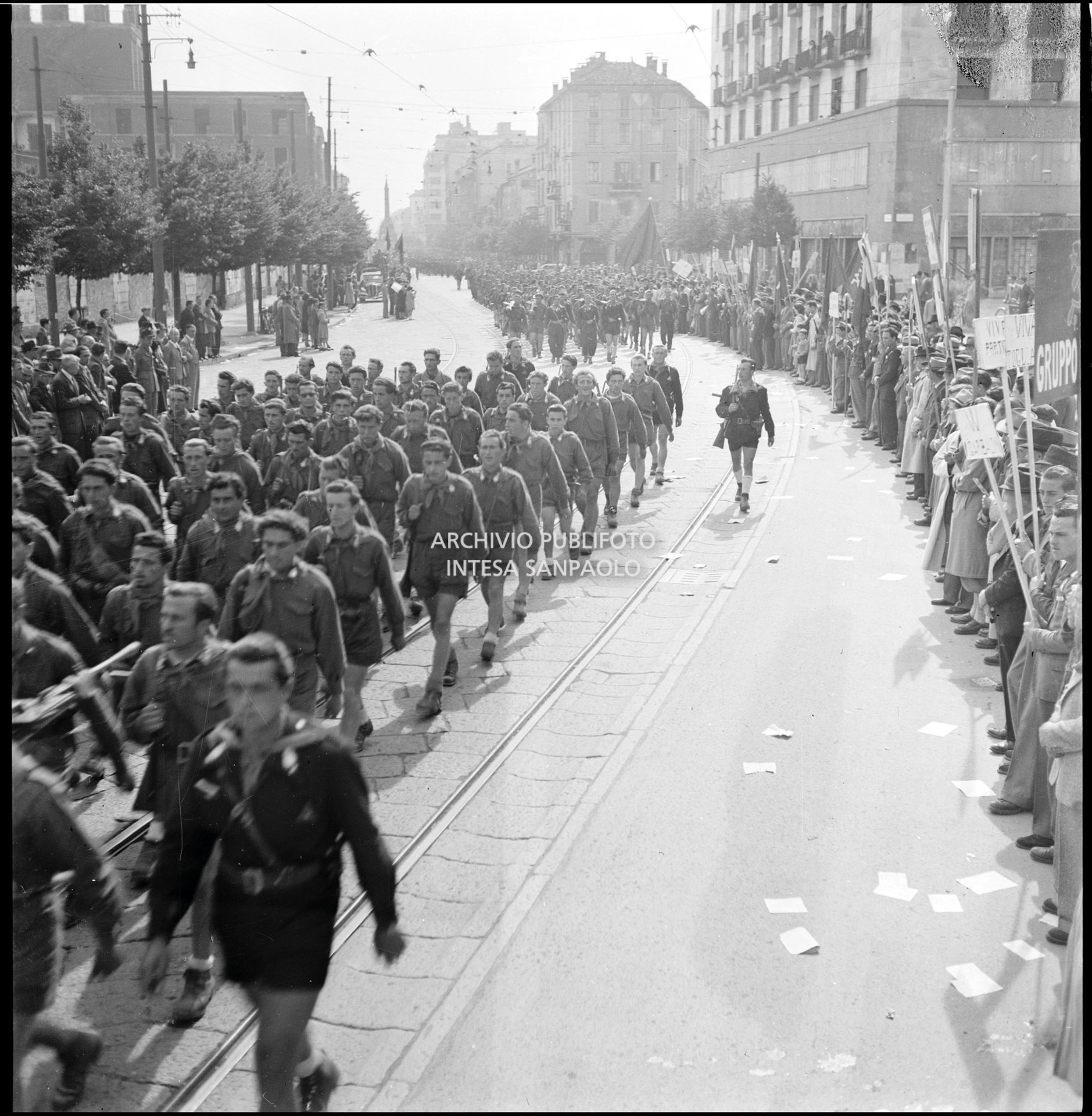 Le formazioni partigiane sfilano in corso di Porta Vittoria a Milano; ai lati la folla accorsa per festeggiarle