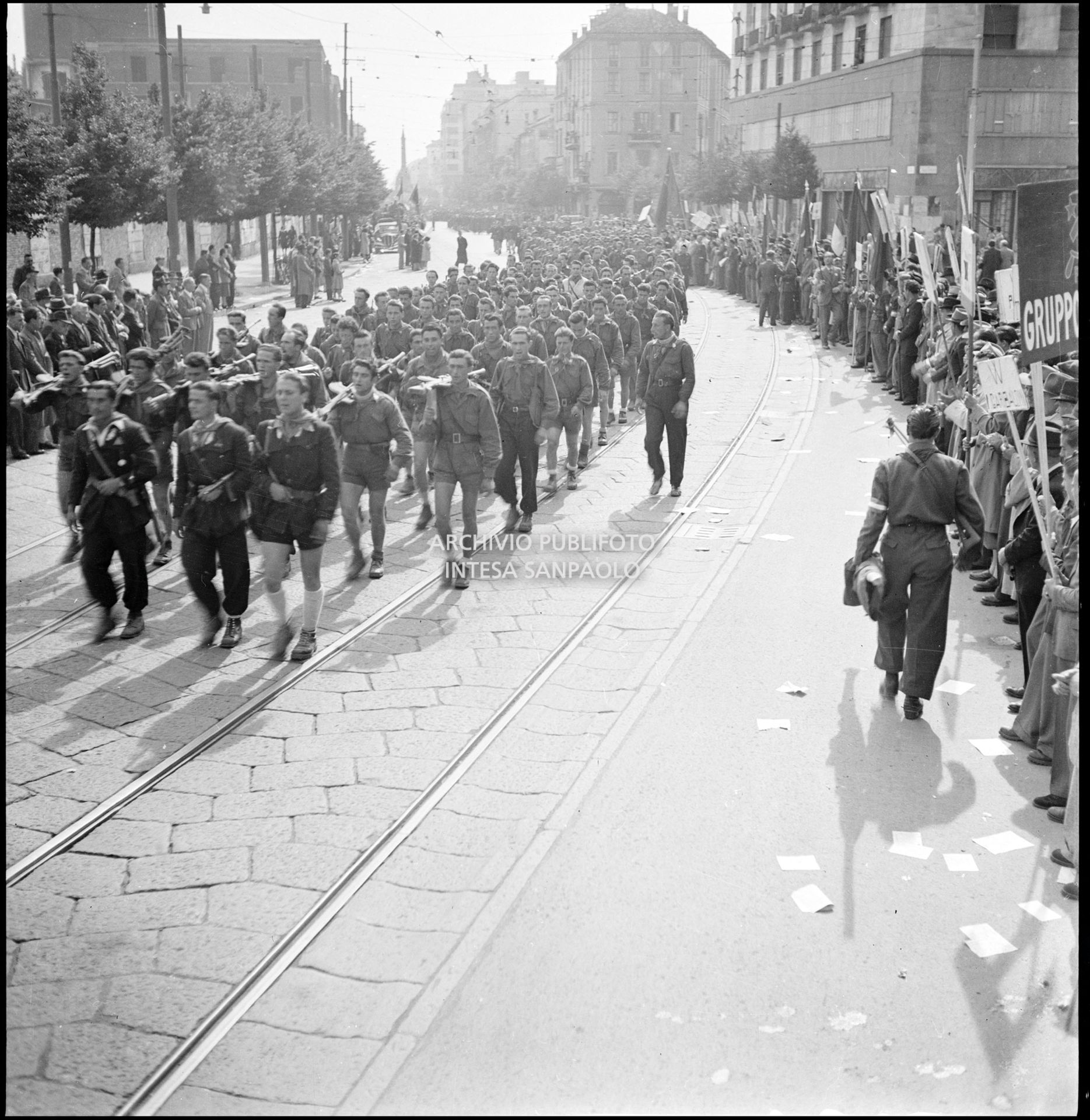 Le formazioni partigiane sfilano in corso di Porta Vittoria a Milano; ai lati la folla accorsa per festeggiarle