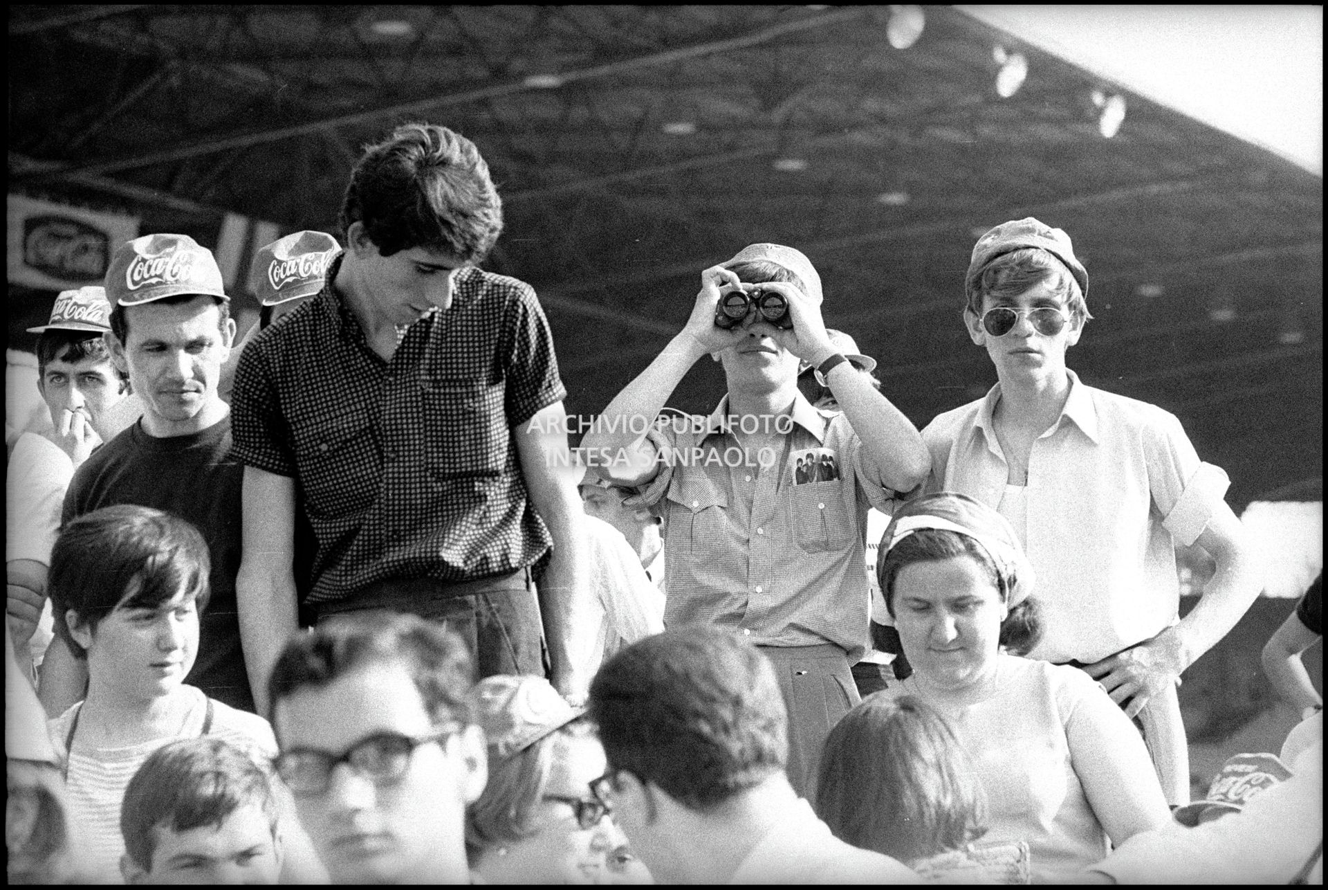 Pubblico al concerto pomeridiano dei Beatles al Vigorelli di Milano; un ragazzo osserva con il binocolo