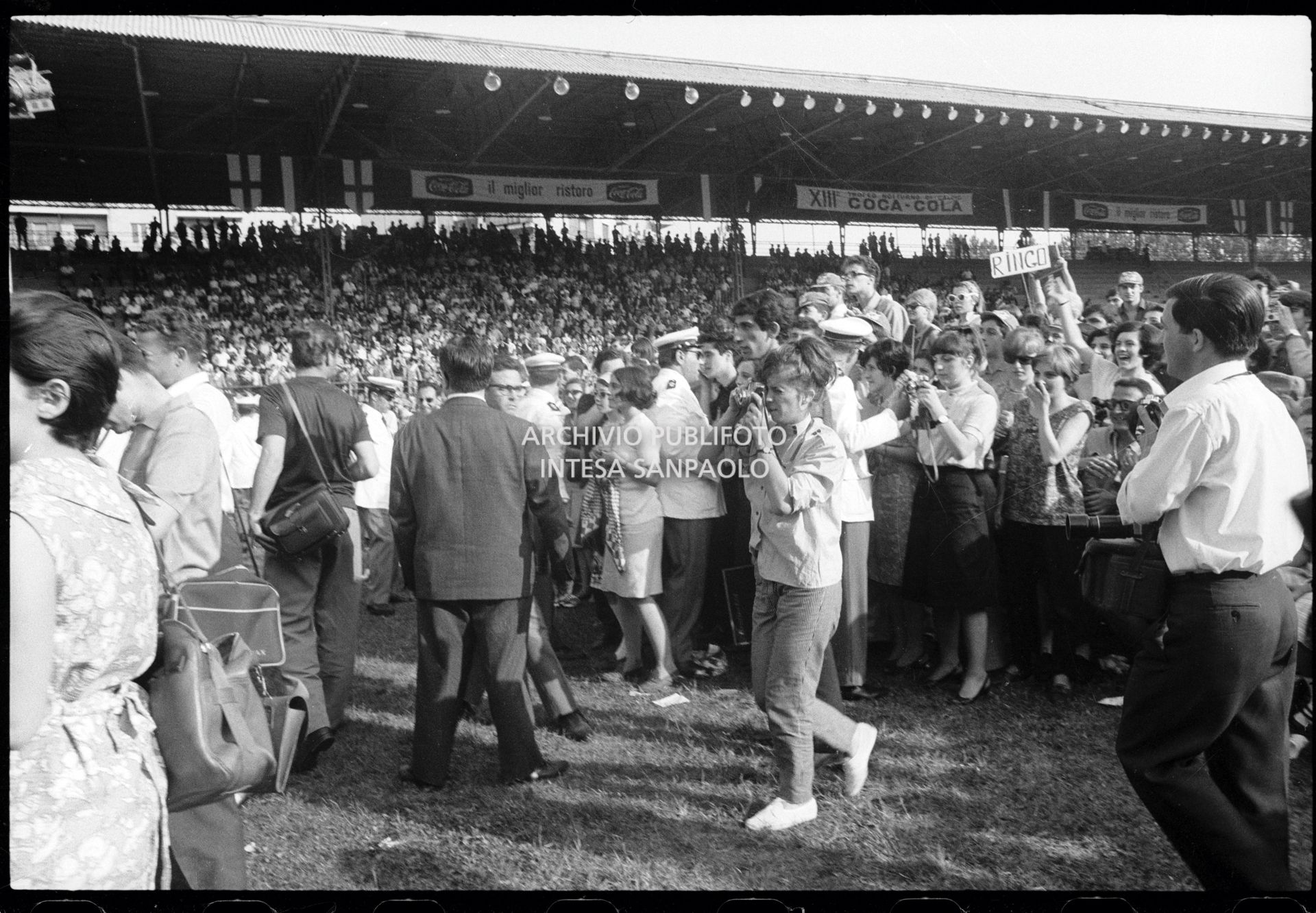 Pubblico al concerto pomeridiano dei Beatles al Vigorelli di Milano; molti ragazzi impugnano una macchina fotografica per immortalare l'evento