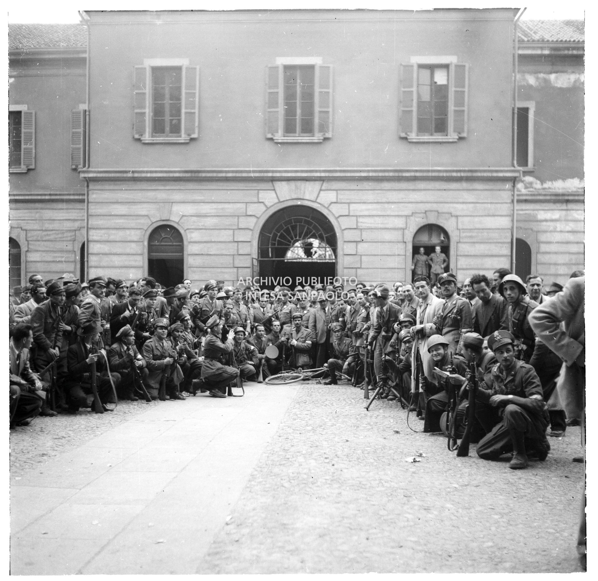 Foto ricordo di militari della Guardia di Finanza e di partigiani nel cortile della caserma Cinque Giornate in via Melchiorre Gioia