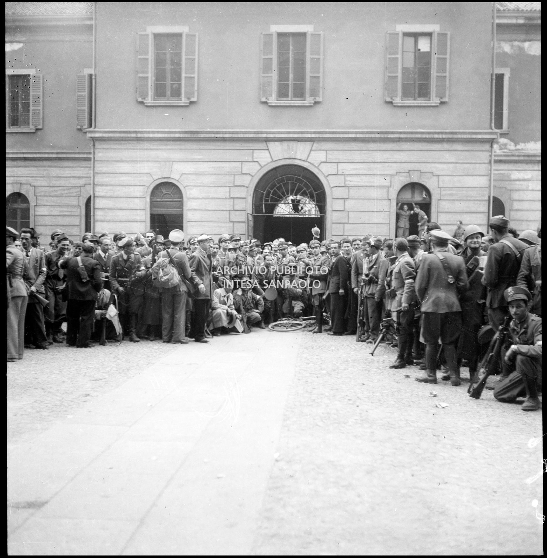 Foto ricordo di militari della Guardia di Finanza e di partigiani nel cortile della caserma Cinque Giornate in via Melchiorre Gioia