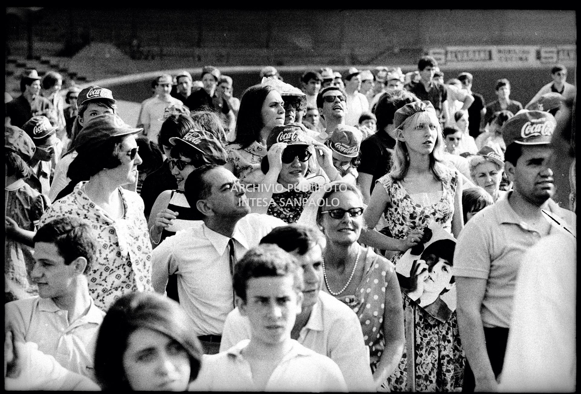 Pubblico al concerto pomeridiano dei Beatles al Vigorelli di Milano; una ragazza tiene in mano la fotografia di Paul McCartney
