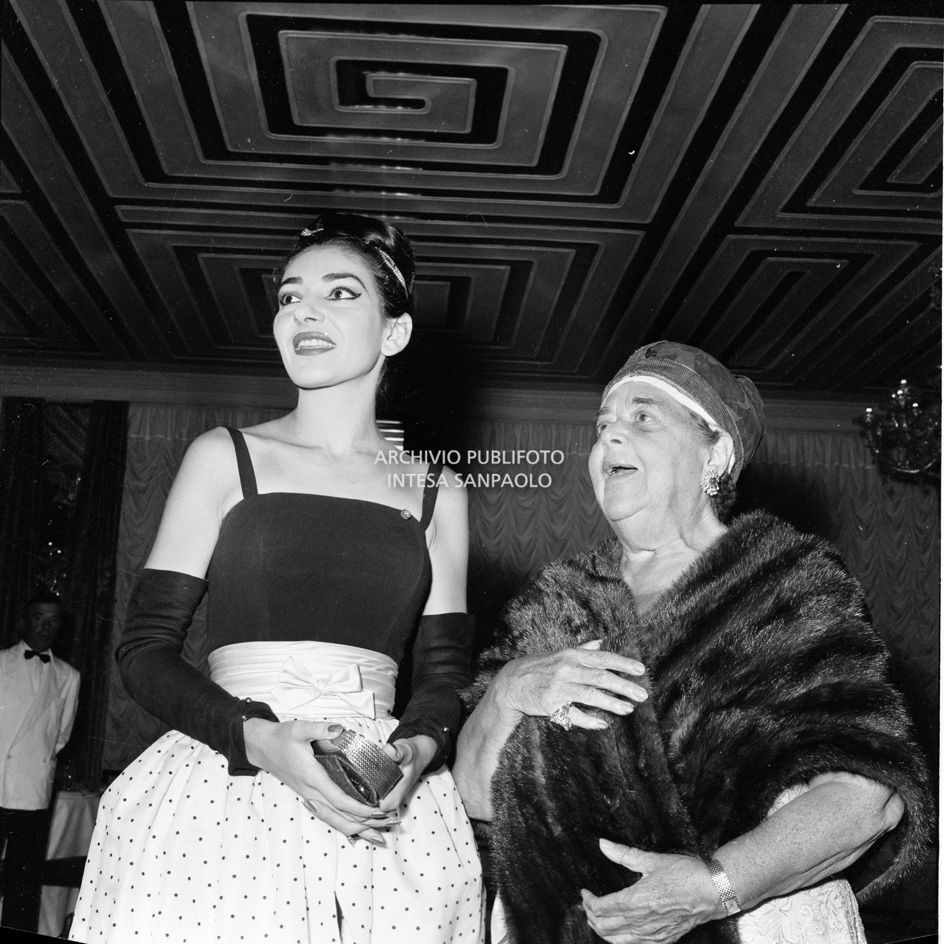 Maria Callas in compagnia di Elsa Maxwell al ricevimento che quest'ultima ha organizzato in suo onore