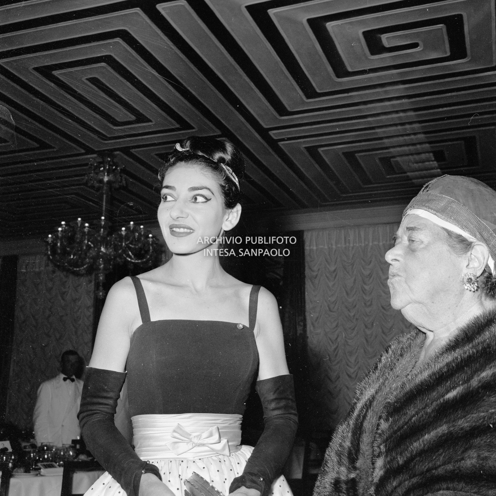 Maria Callas in compagnia di Elsa Maxwell al ricevimento che quest'ultima ha organizzato in suo onore