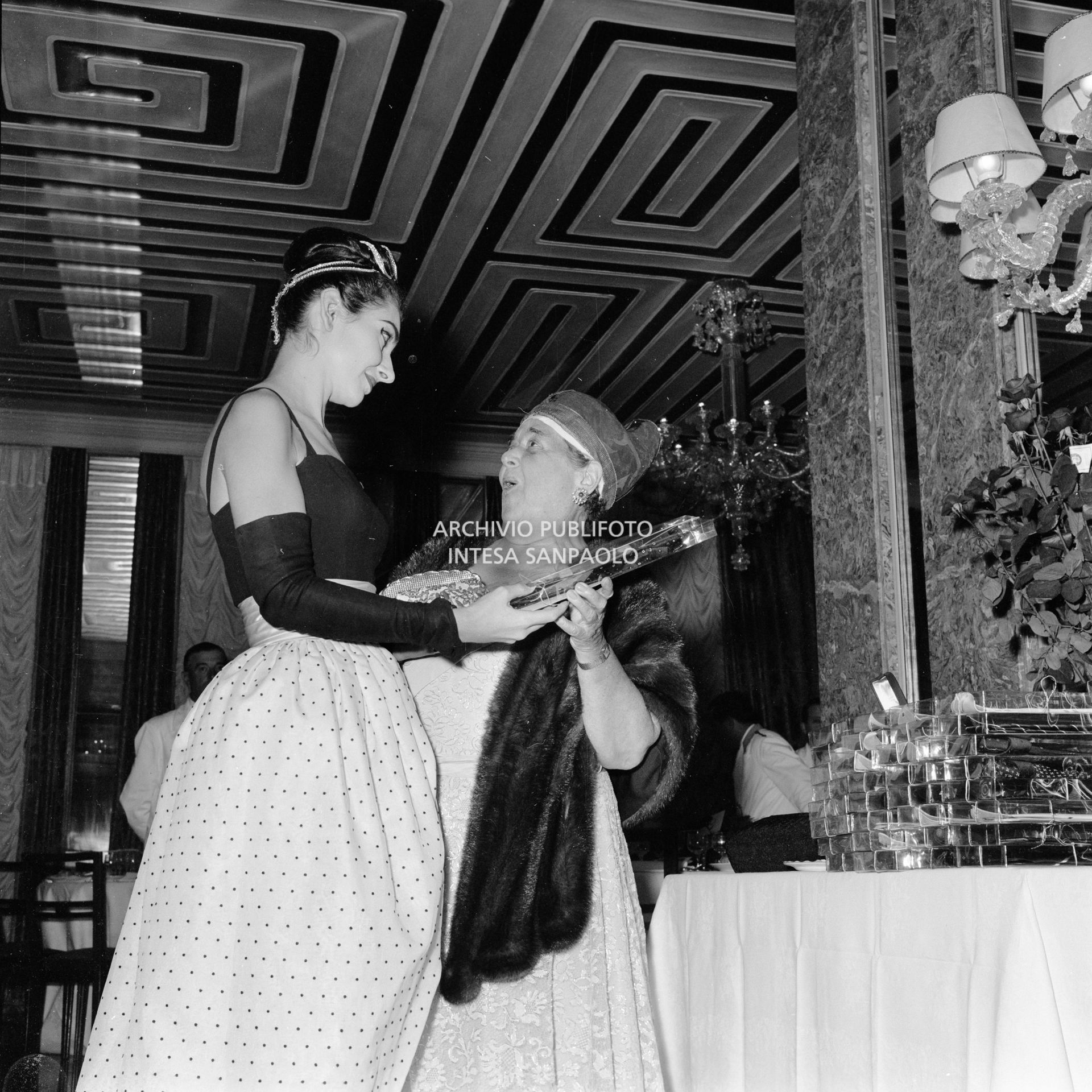 Maria Callas in compagnia di Elsa Maxwell al ricevimento che quest'ultima ha organizzato in suo onore