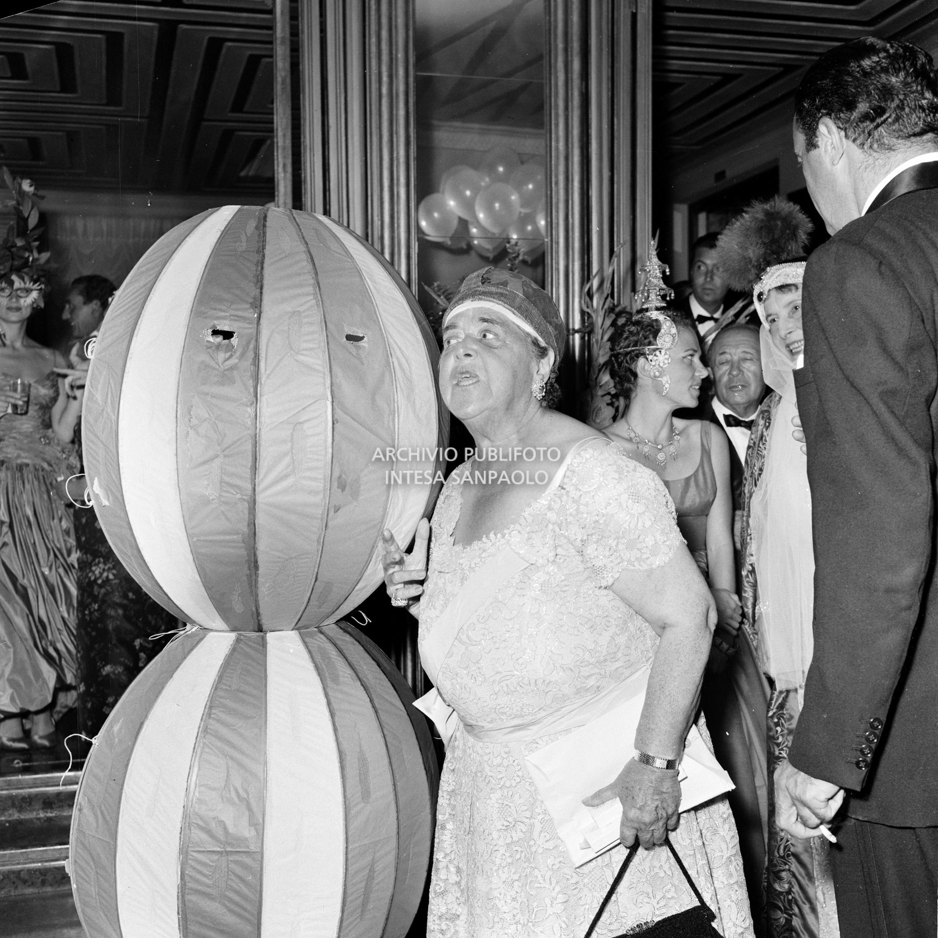 Elsa Maxwell a fianco a Miss Maria Salata Philips avvolta da un curioso costume al ricevimento organizzato dalla giornalista americana in onore di Maria Callas