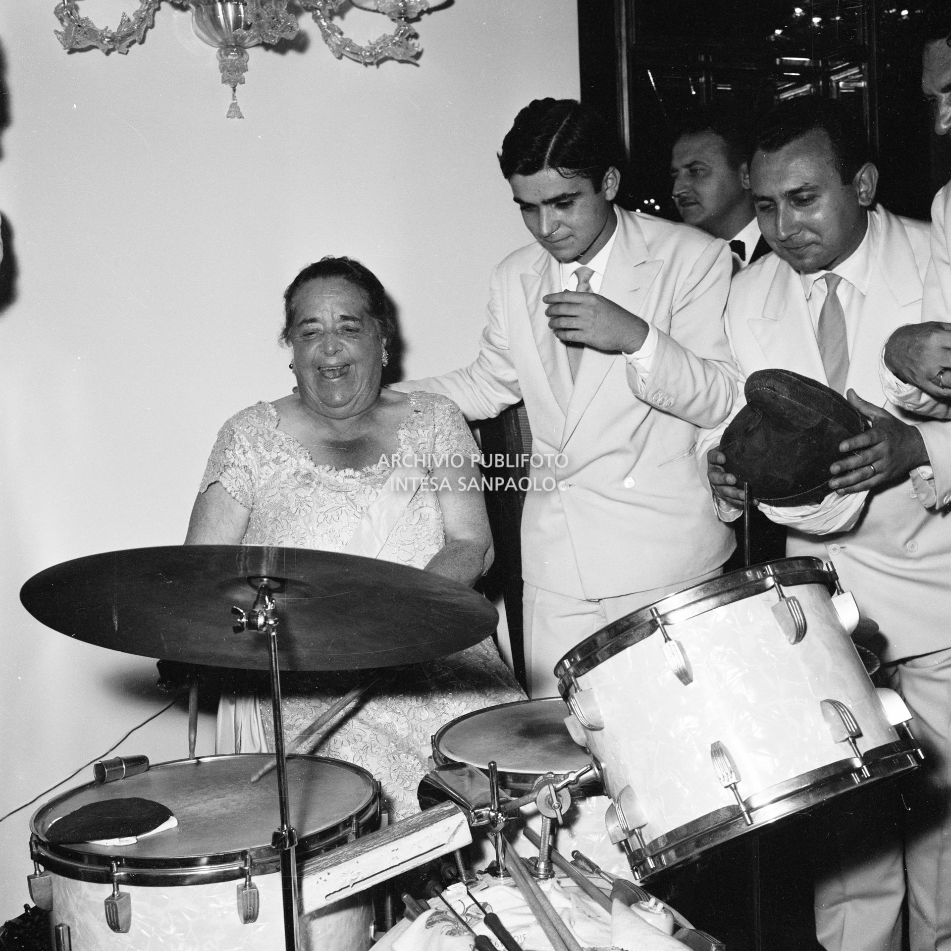 Elsa Maxwell suona la batteria circondata dai musicisti che intrattengono gli ospiti al ricevimento che la giornalista americana ha organizzato in onore di Maria Callas