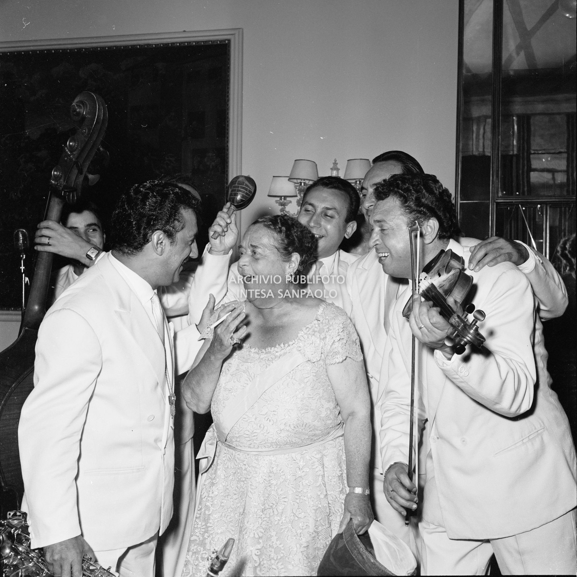 Elsa Maxwell canta accompagnata dai musicisti che intrattengono gli ospiti al ricevimento che la giornalista americana ha organizzato in onore di Maria Callas