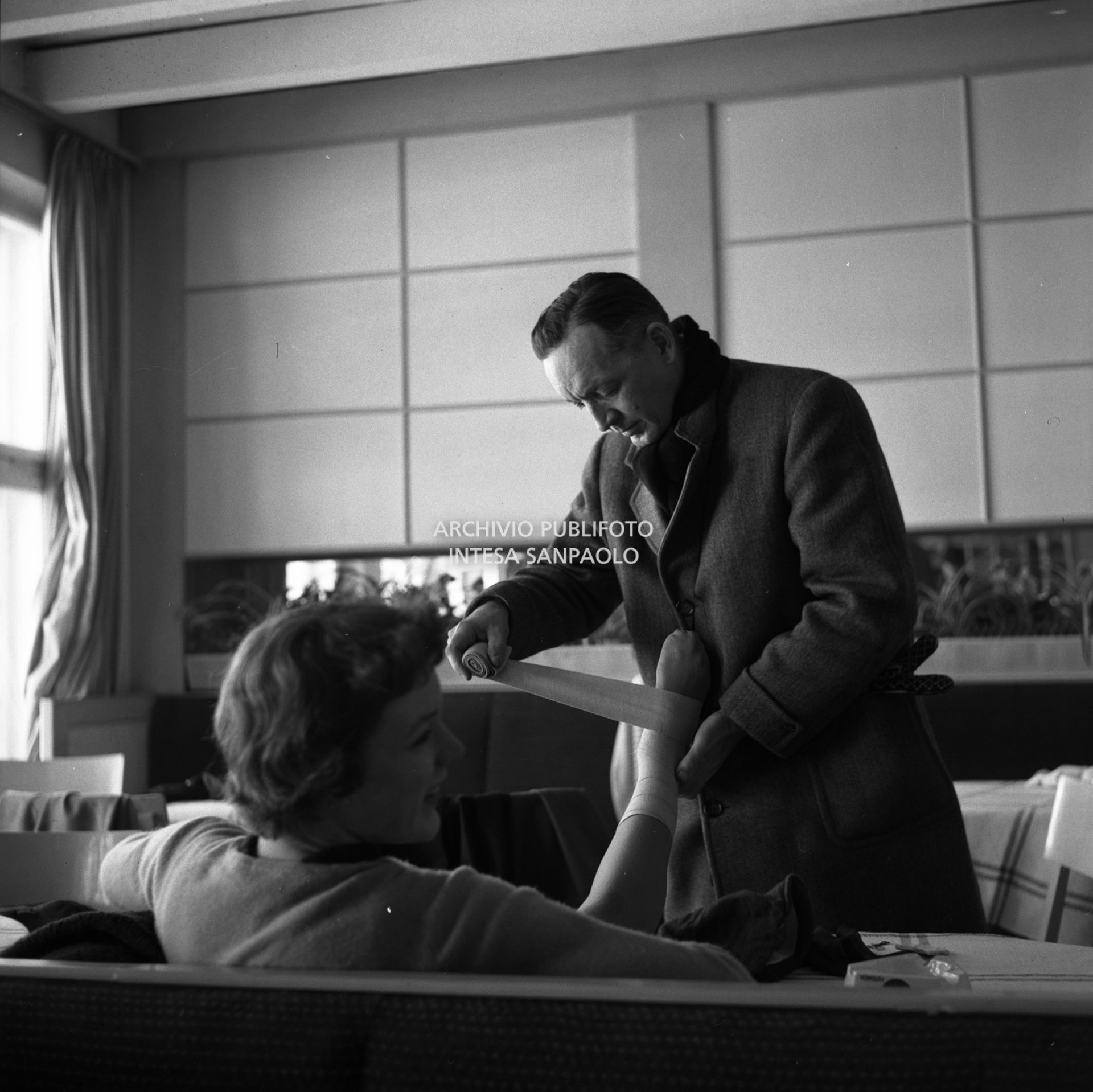 Hollis Albright fascia la caviglia della figlia Tenley Emma Albright, pattinatrice artistica americana, a Cortina d'Ampezzo per i VII Giochi olimpici invernali