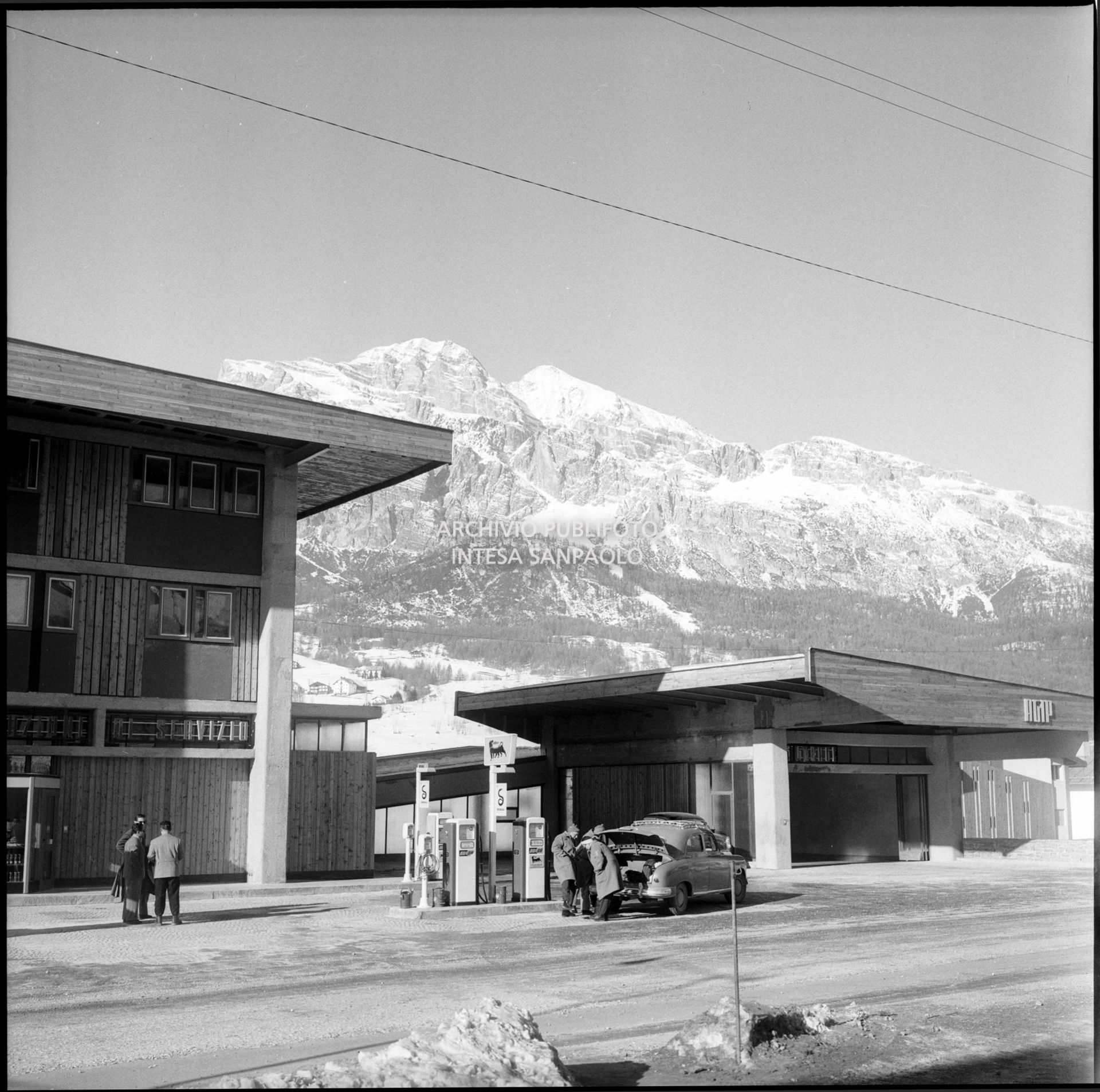 Un'automobile in rifornimento al distributore di carburante Agip presso la stazione di servizio nei pressi di Cortina d'Ampezzo nel periodo dei VII Giochi olimpici  invernali