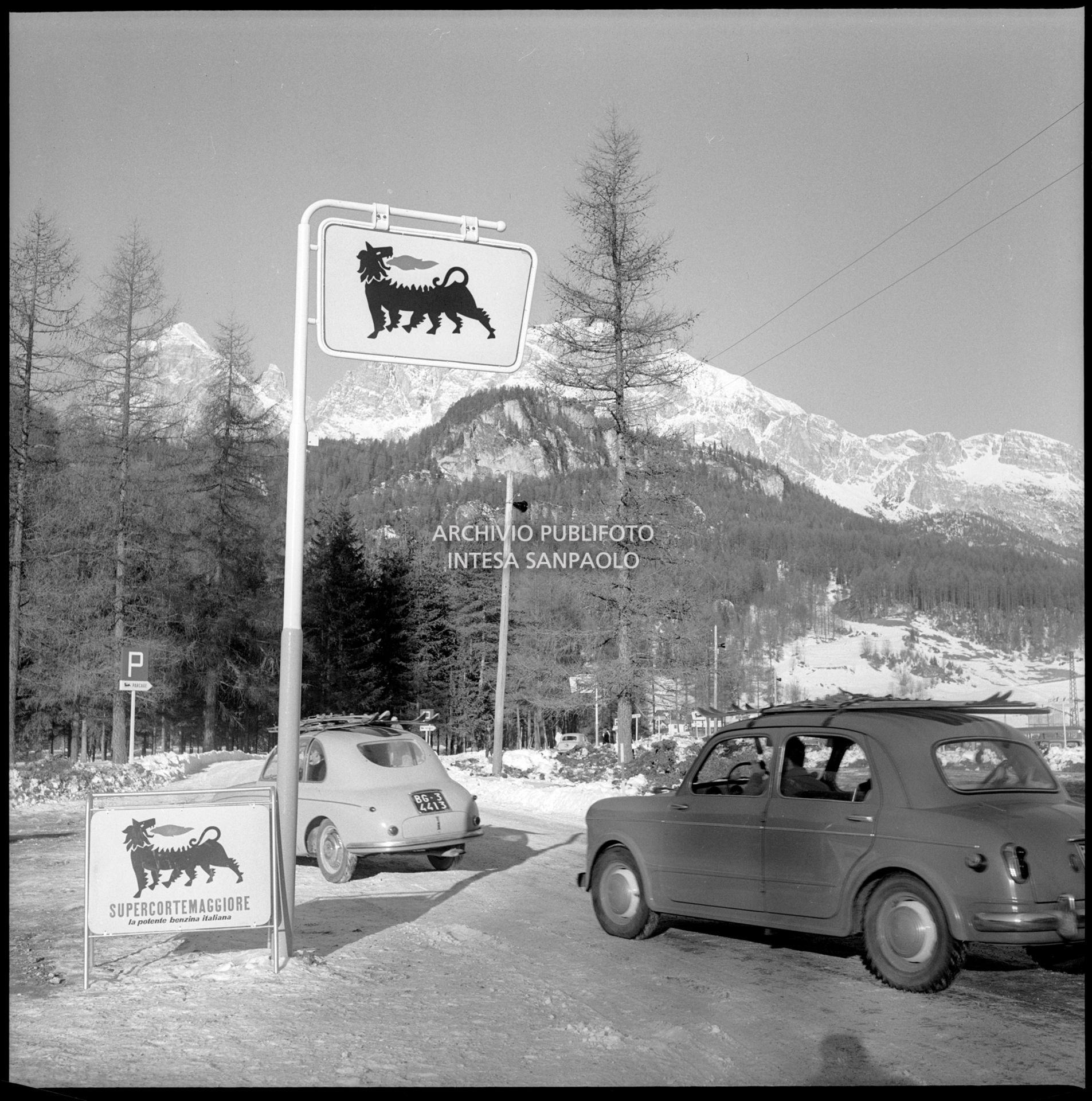 Insegna di un distributore di benzina Agip Supercortemaggiore e relativo cartello nei pressi di Cortina d'Ampezzo nel periodo dei VII Giochi olimpici invernali