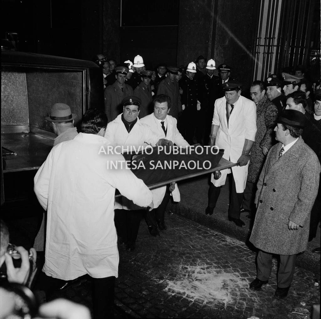 La salma di una vittima mentre viene caricata sul carro funebre