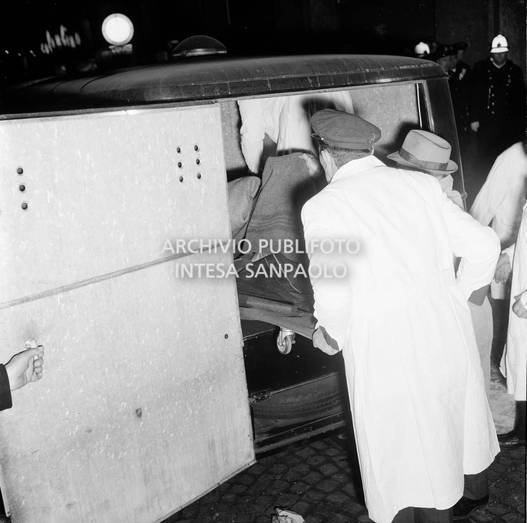 La salma di una vittima mentre viene caricata sul carro funebre