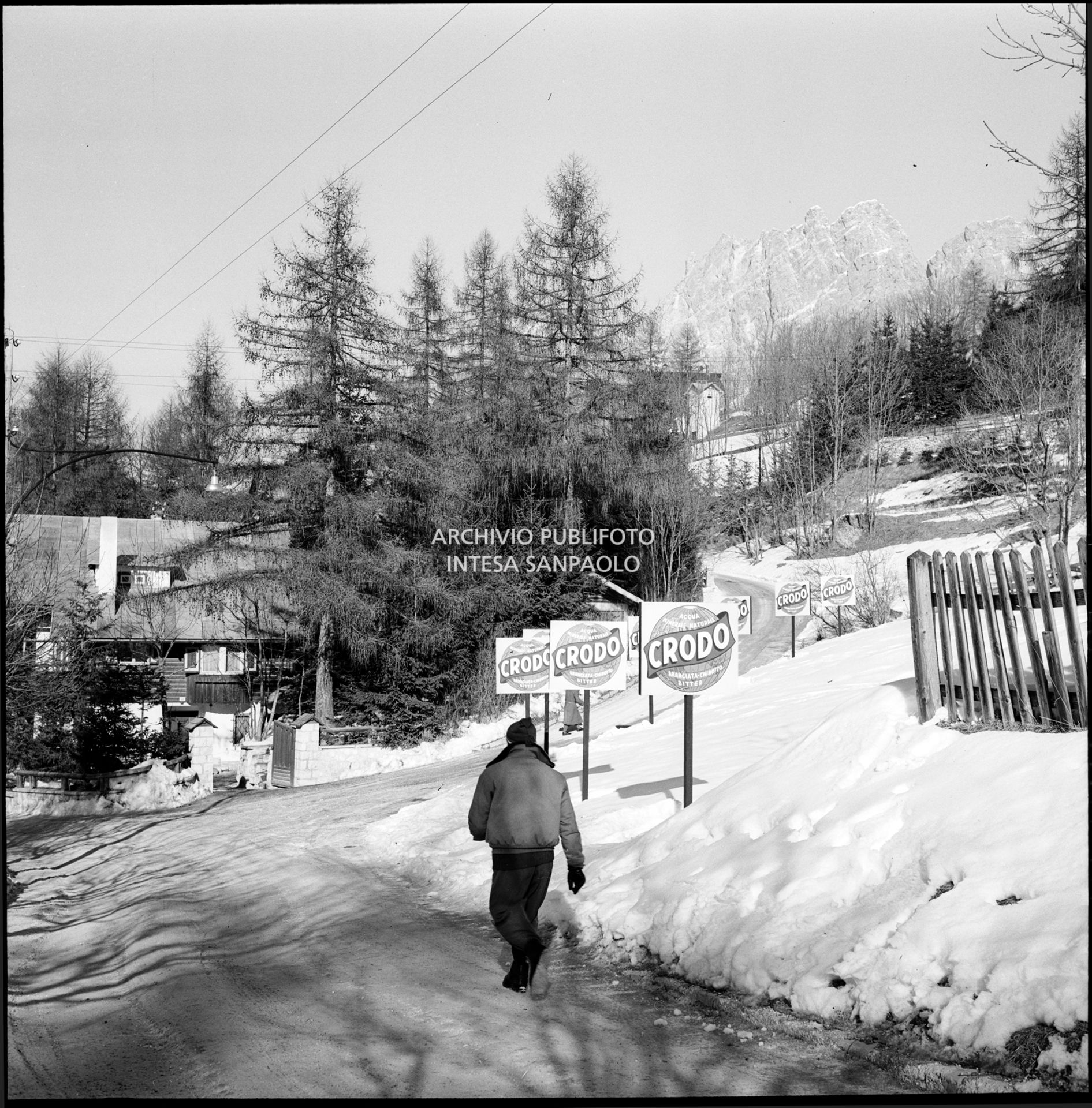 Cartelli pubblicitari dell'acqua e delle bibite Crodo lungo una strada a Cortina d'Ampezzo