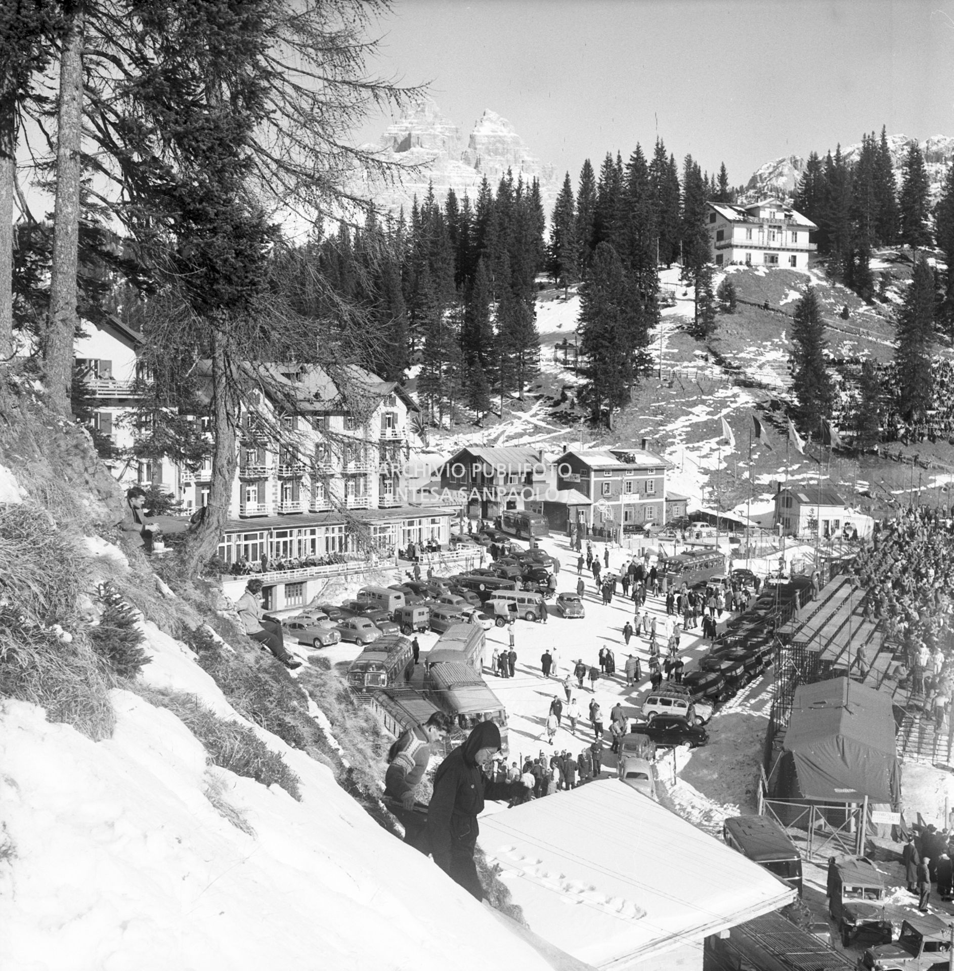 Scorcio del Grand Hotel Misurina, dei mezzi parcheggiati e delle tribune sulla pista di pattinaggio di velocità allestita sul lago di Misurina durante i VII Giochi olimpici invernali