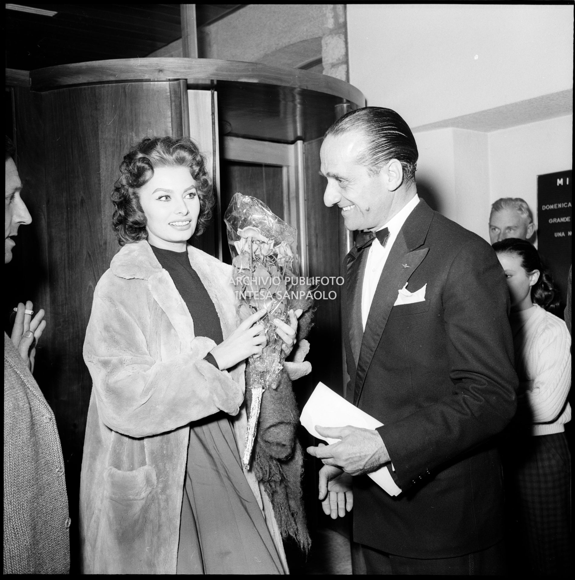 Sophia Loren, al suo arrivo a Cortina d'Ampezzo in occasione dei VII Giochi olimpici invernali, con un mazzo di fiori in mano