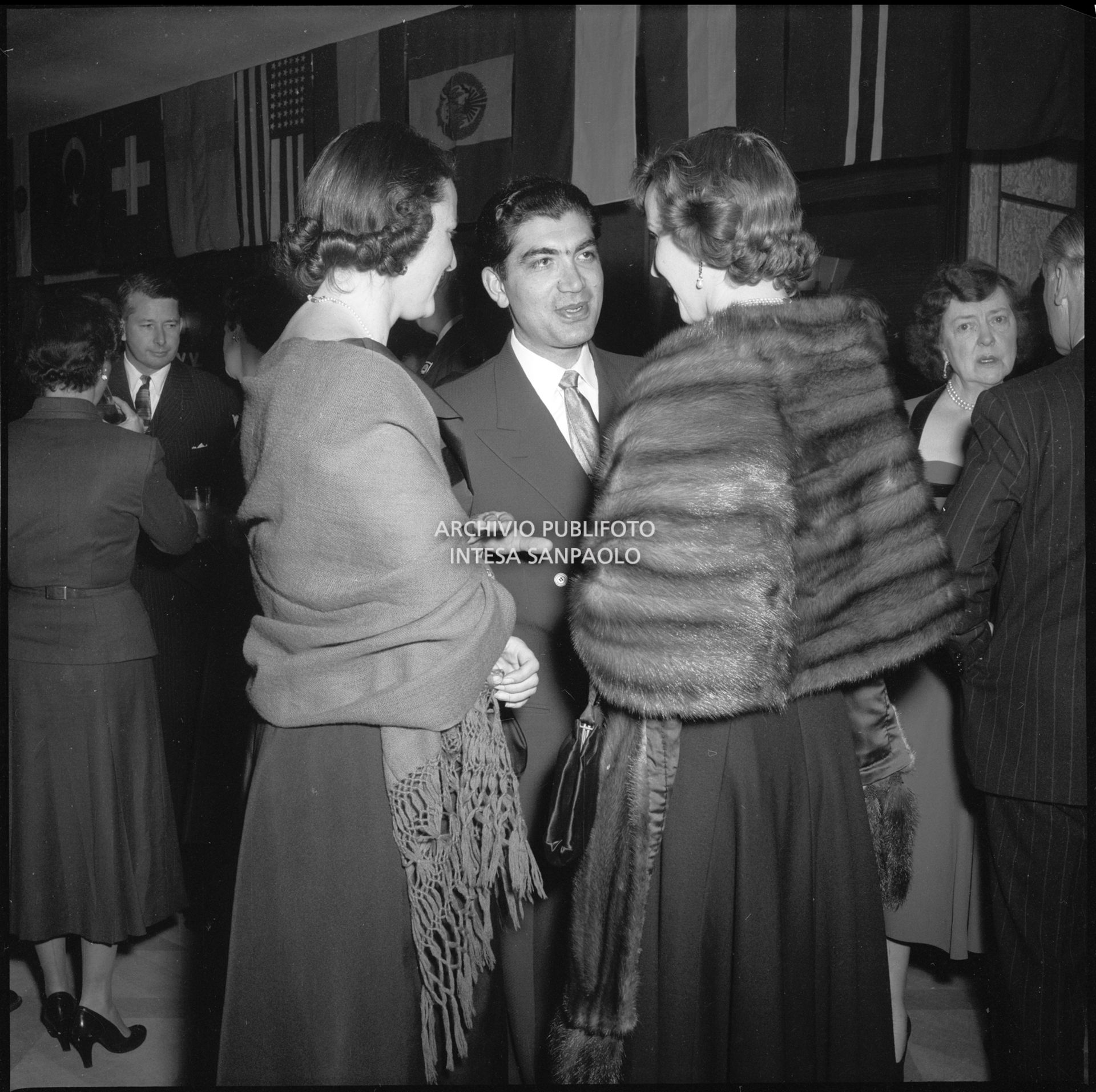 Gholam Rezi Pahlavi, presidente della Commissione olimpica iraniana a Cortina d'Ampezzo in occasione dei VII Giochi olimpici invernali, in compagnia di due donne