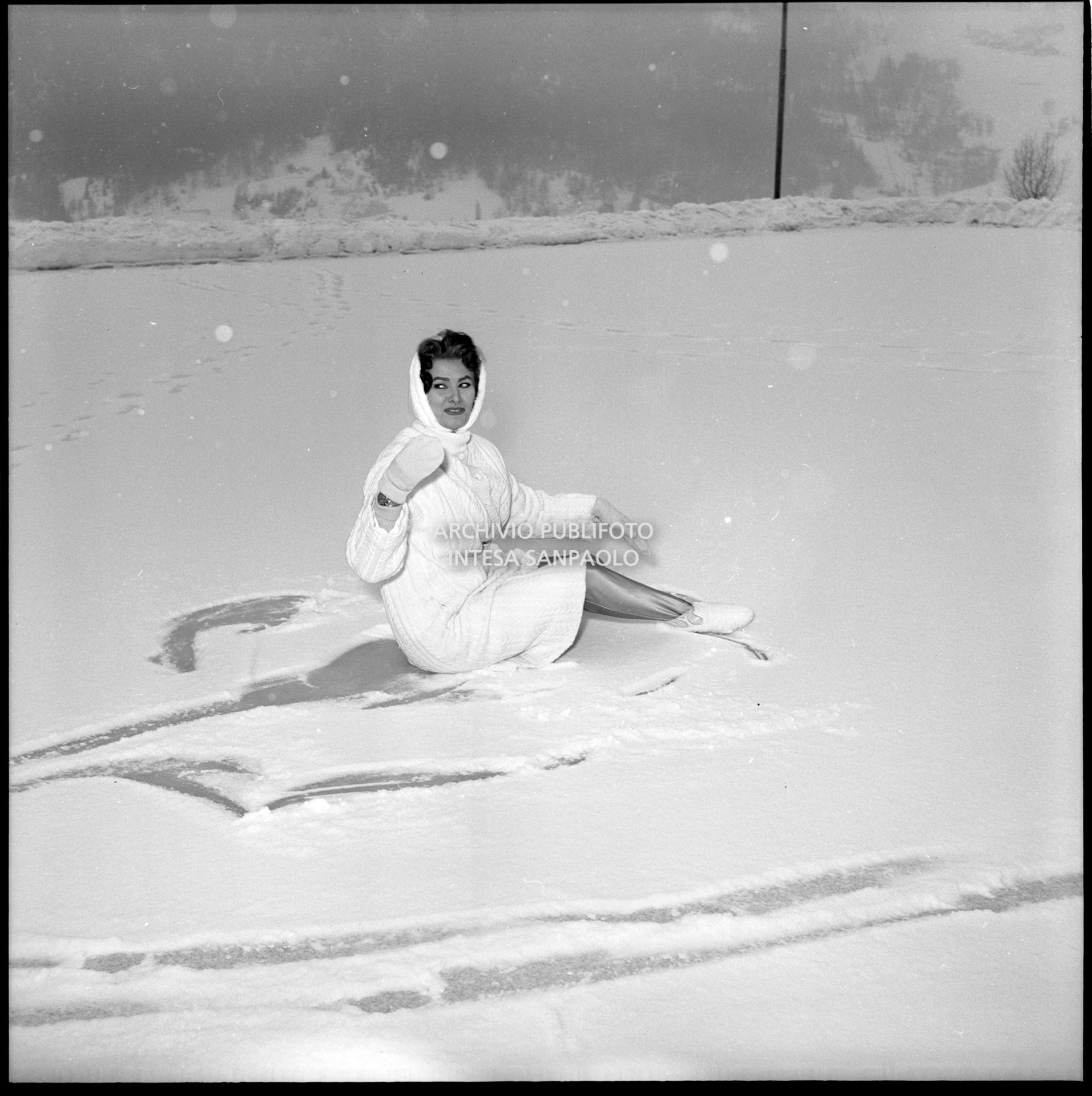 Sophia Loren seduta sul ghiaccio a Cortina d'Ampezzo in occasione della sua visita durante i VII Giochi olimpici invernali