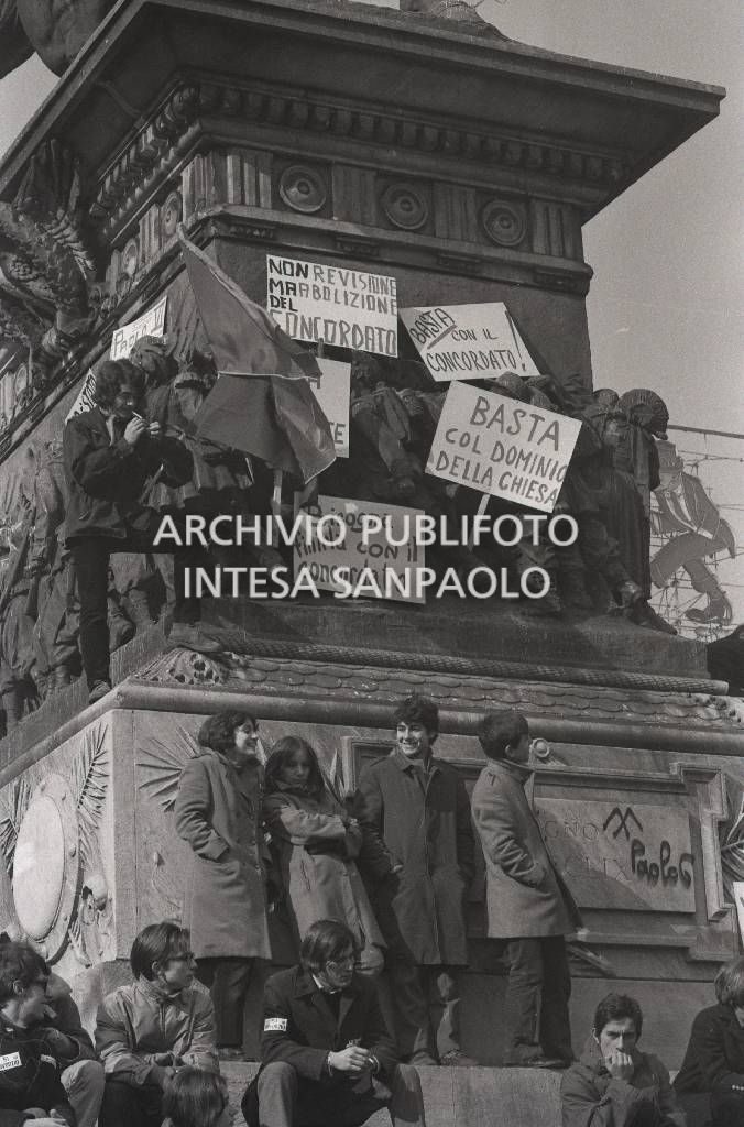 Studenti, con cartelli di protesta contro il Concordato Stato/Chiesa, sul monumento a Vittorio Emanuele II in piazza Duomo a Milano