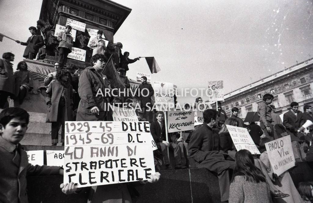Studenti, con cartelli di protesta contro il Concordato Stato/Chiesa, sul monumento a Vittorio Emanuele II in piazza Duomo a Milano