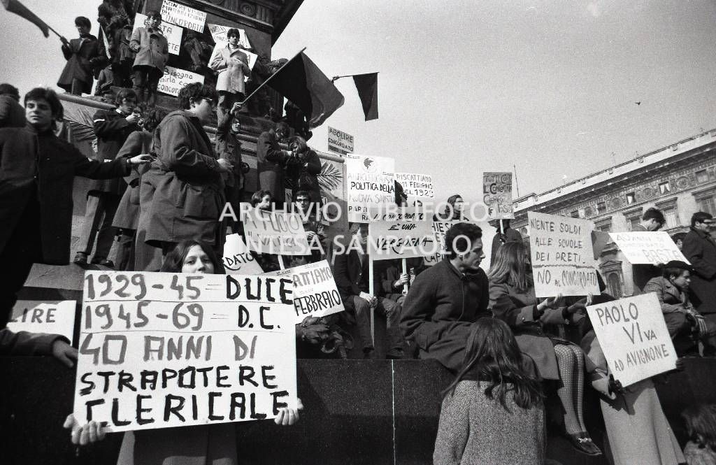 Studenti, con cartelli di protesta contro il Concordato Stato/Chiesa, sul monumento a Vittorio Emanuele II in piazza Duomo a Milano
