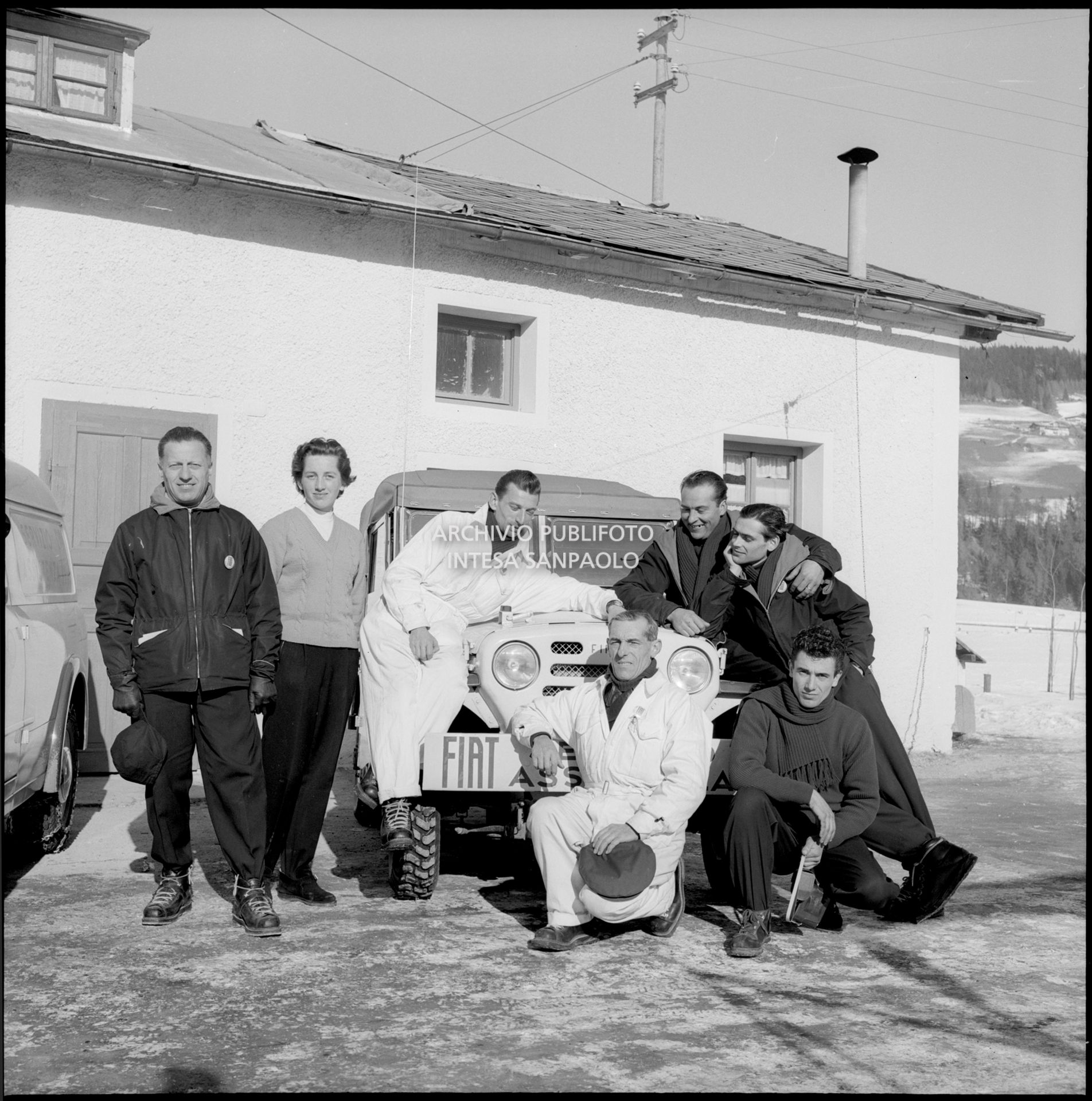 La sciatrice alpina Madeleine Berthod posa con alcuni uomini della Fiat vicino a una Fiat Campagnola presso l'officina della casa torinese allestita per i VII Giochi olimpici invernali a Cortina d'Ampezzo