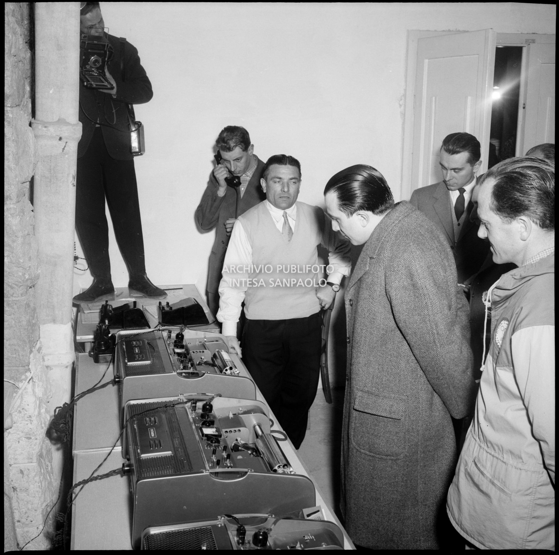 Il ministro delle Finanze Giulio Andreotti visita il reparto delle telefoto del Centro per la stampa ospitato all'albergo Savoia di Cortina d'Ampezzo