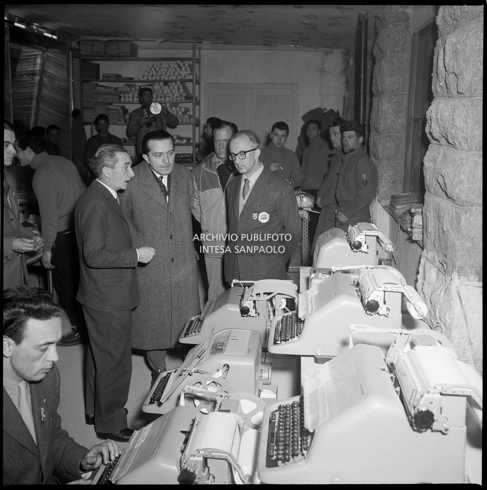 Il ministro delle Finanze Giulio Andreotti vista il reparto telescriventi del Centro per la stampa a Cortina d'Ampezzo; alla sua sinistra, Giuseppe Sabelli Fioretti, direttore del Centro