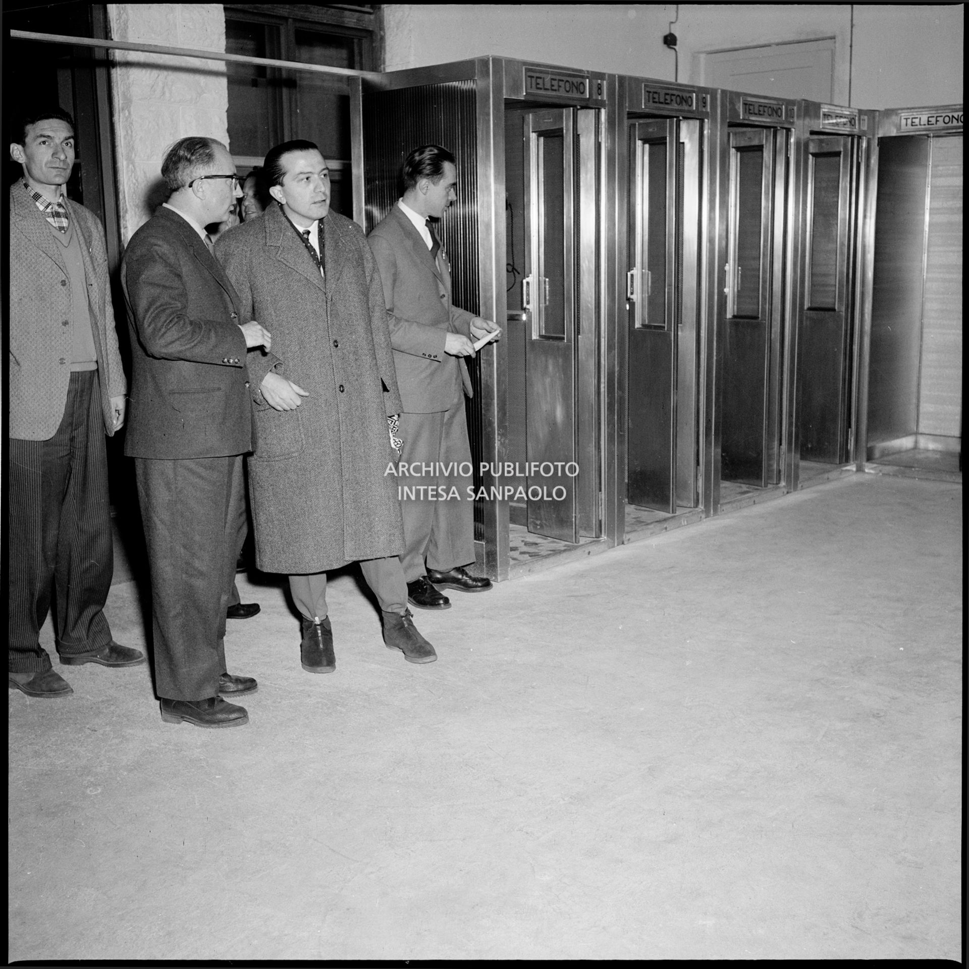 Il direttore del Centro per la stampa, Giuseppe Sabelli Fioretti, mostra al ministro delle Finanze Giulio Andreotti la sala delle cabine telefoniche